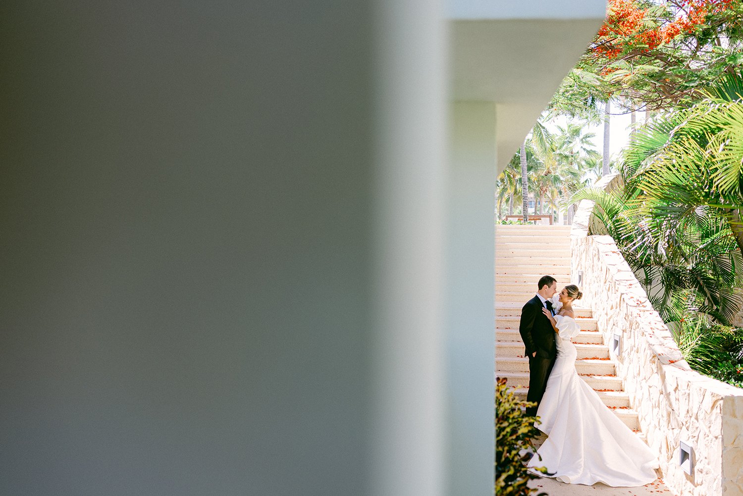 25 sneaking camera capturing bride and groom looking at each other with green palm trees and nature behind at Dreams Riviera Cancun.JPG