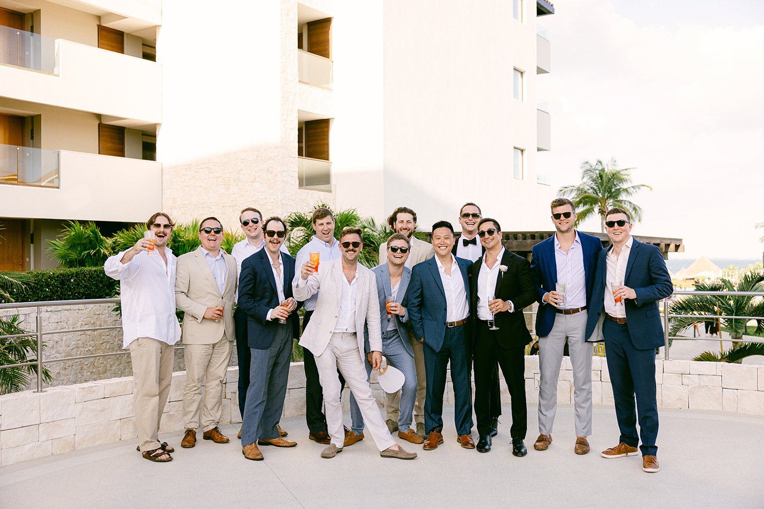 40 happy male wedding guests enjoying cocktail hour drinking signature cocktails at Dreams Riviera Cancun.JPG