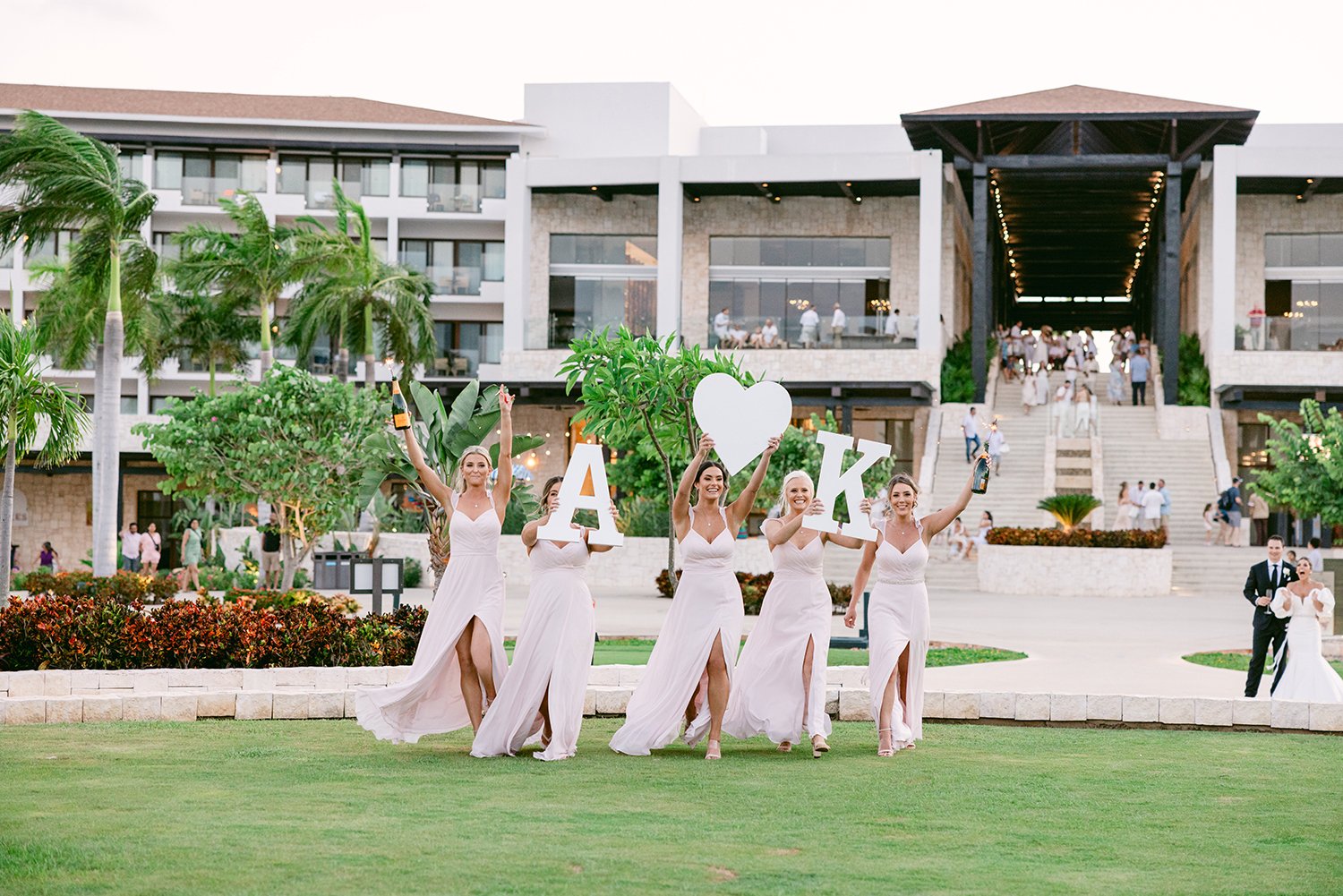53 wedding bridesmaids celebrating grand entrance with big bride and groom initials sign at Dreams Riviera Cancun.JPG