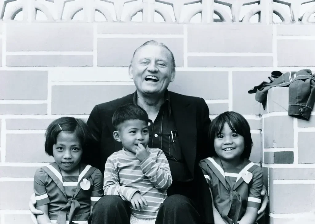 Our founder, Les, sitting with a few children the mission has helped.