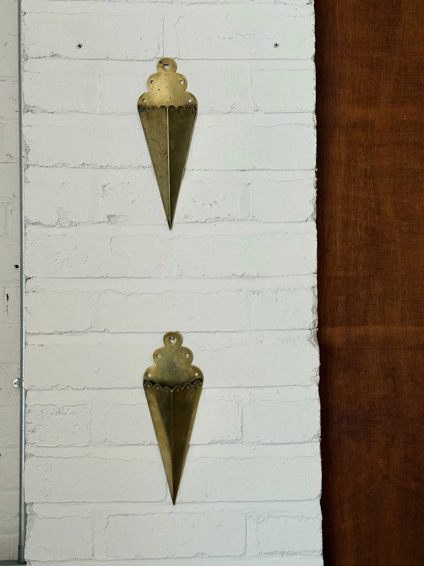 These lovely weighty brass wall pockets were originally made for the fireside. Scalloped edge detail accompanies a vintage but contemporary shape. 
Vintage condition with used patina. 
Approx: 27cm
Dm for price.