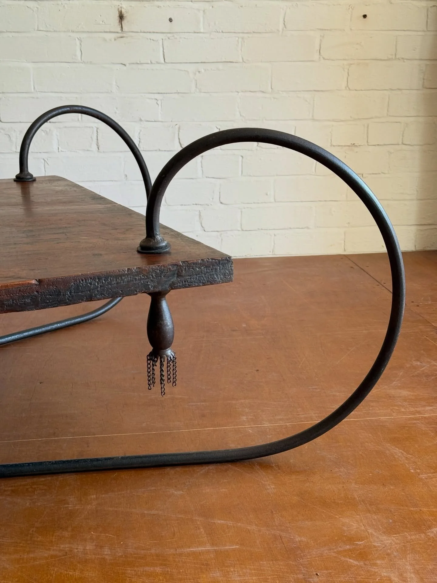 A quite extraordinary &amp; sizeable monolithic hardwood coffee table with handcrafted blacksmith made iron frame suspending a teak wood slab (possibly Iroko), all held in place with custom hand turned threaded steel tassels. Possibly made for outsid