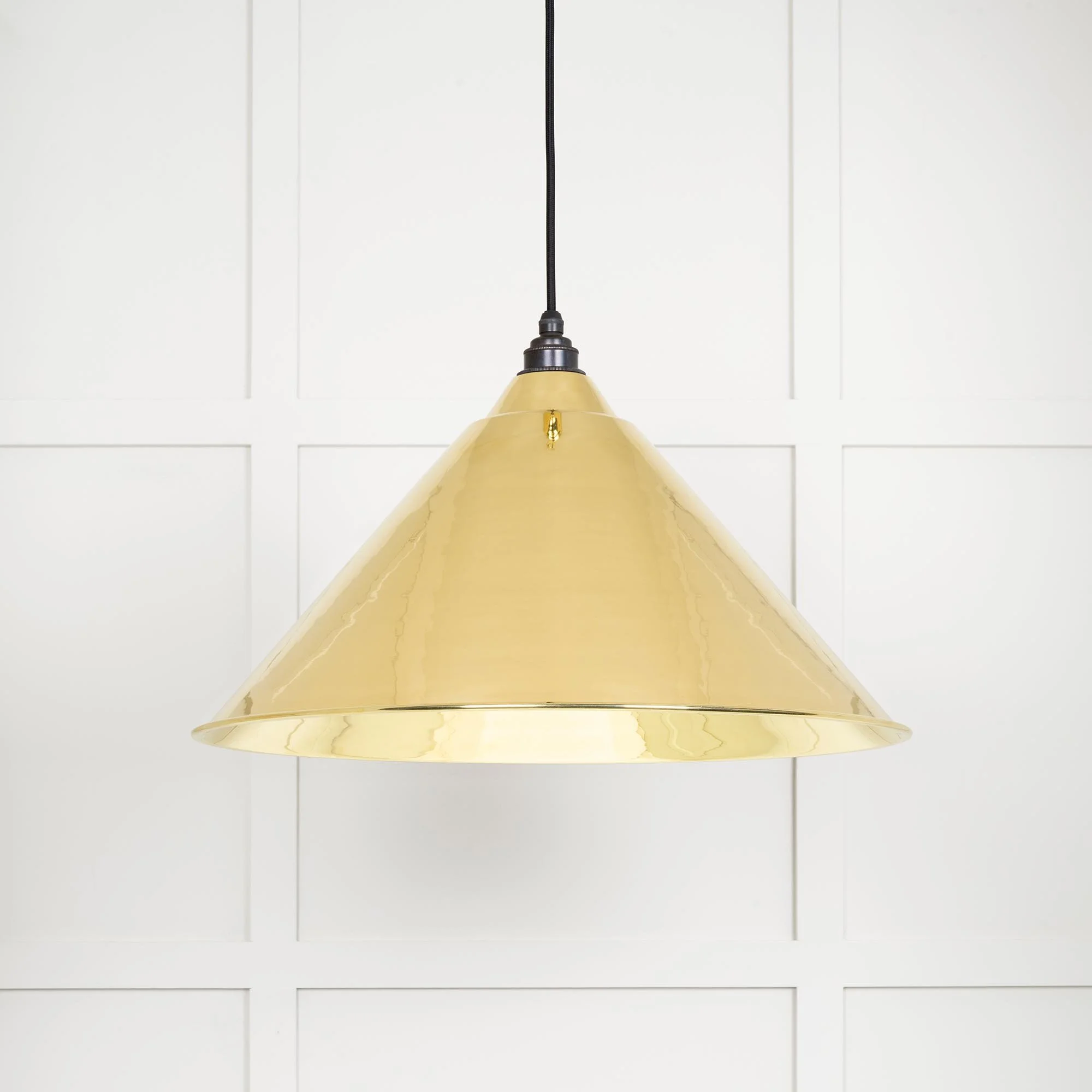 Oversized Hawthorne brass pendant lamp emitting soft ambient light, perfect for statement interiors.