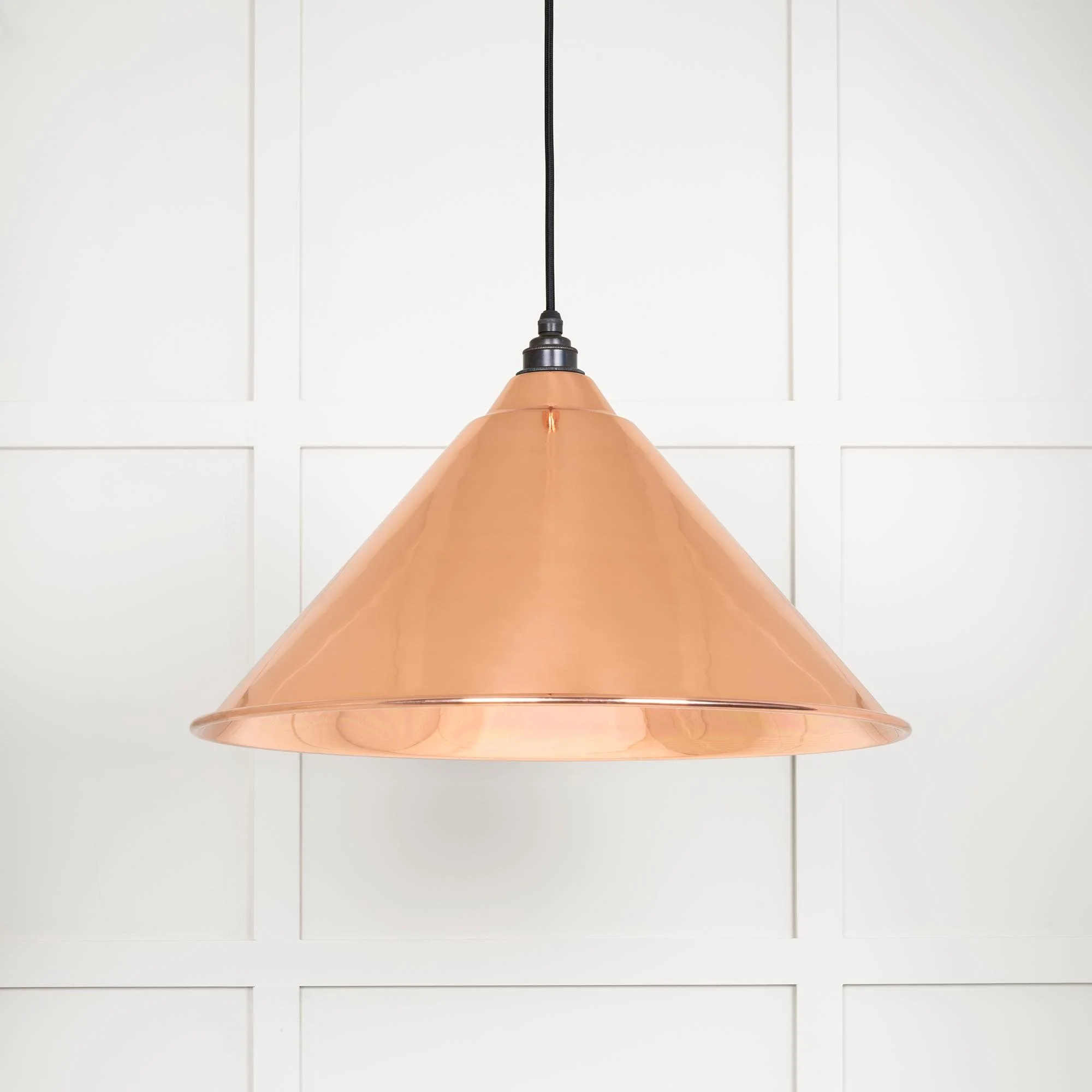 Oversized copper pendant lamp emitting a soft ambient glow in a contemporary interior