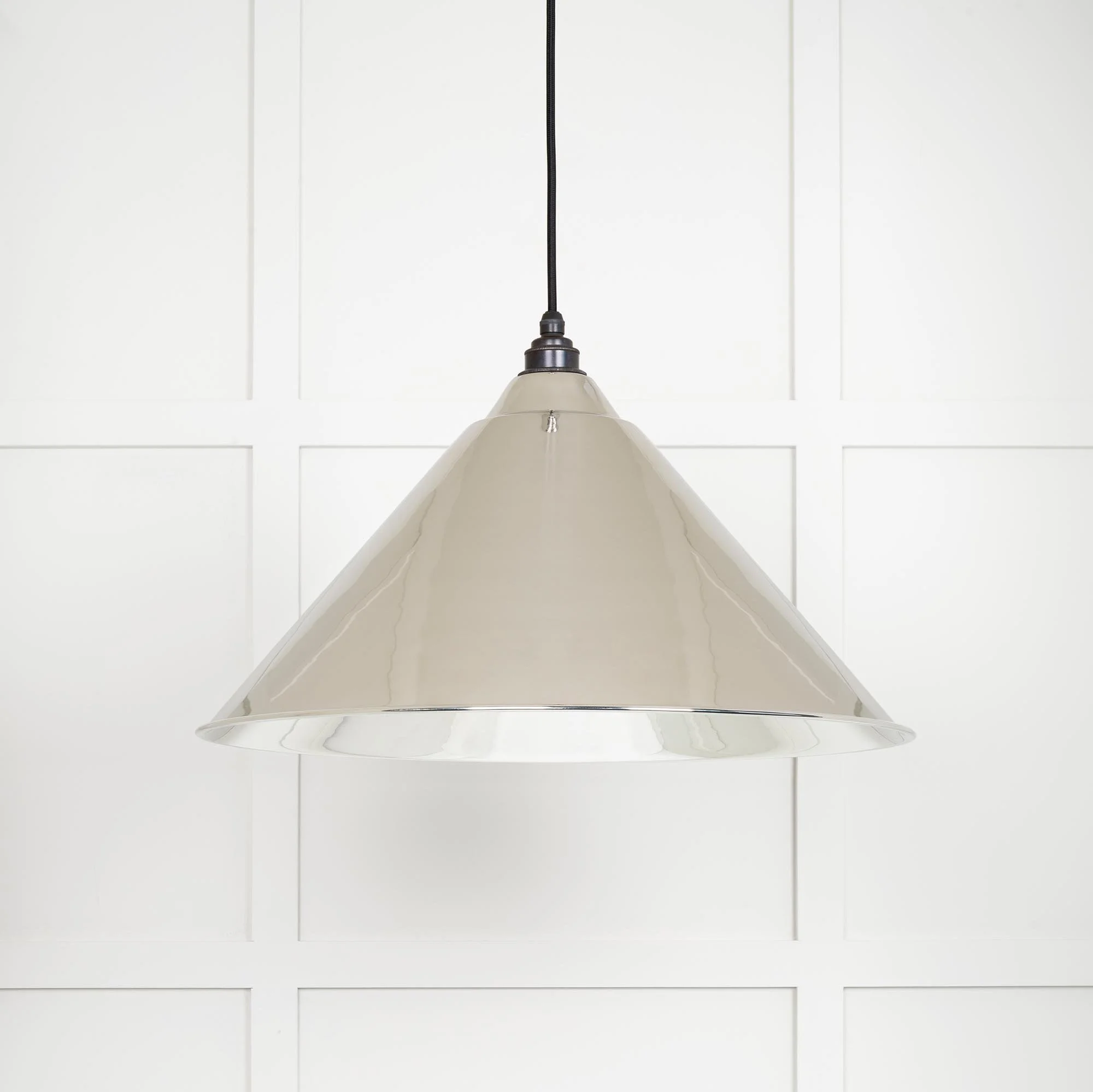 Oversized Hawthorne nickel pendant lamp emitting soft ambient glow in a contemporary interior