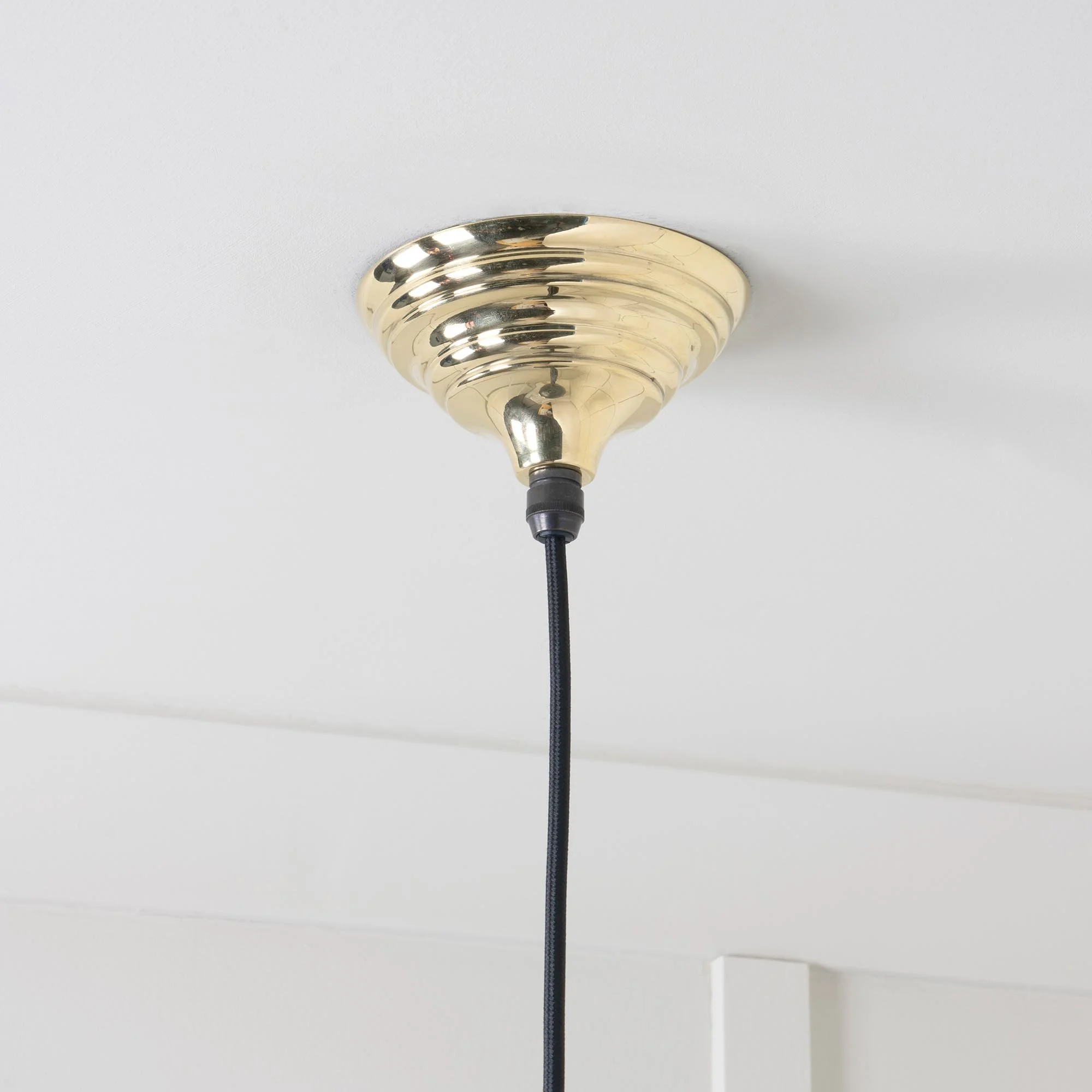 Oversized Hawthorne brass pendant lamp emitting soft ambient light, perfect for statement interiors.
