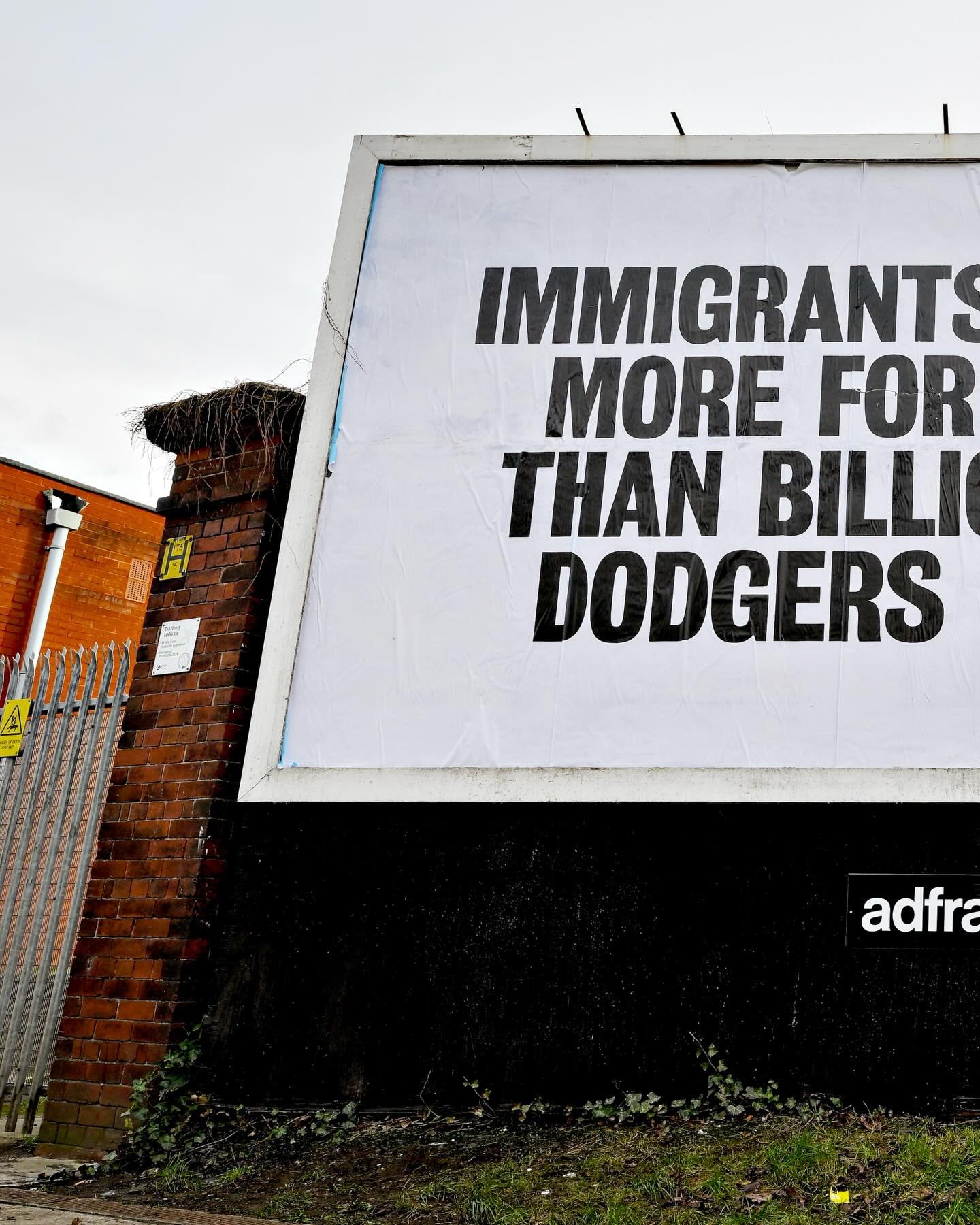A billboard poster aimed at Manchester United Co-Owner Jim Ratcliffe is seen outside the stadium stating, &lsquo;Immigrants Have done More For This City Than Billionaire Tax Dodgers Ever Will&rsquo; at Old Trafford on February 13, 2026 in Manchester,