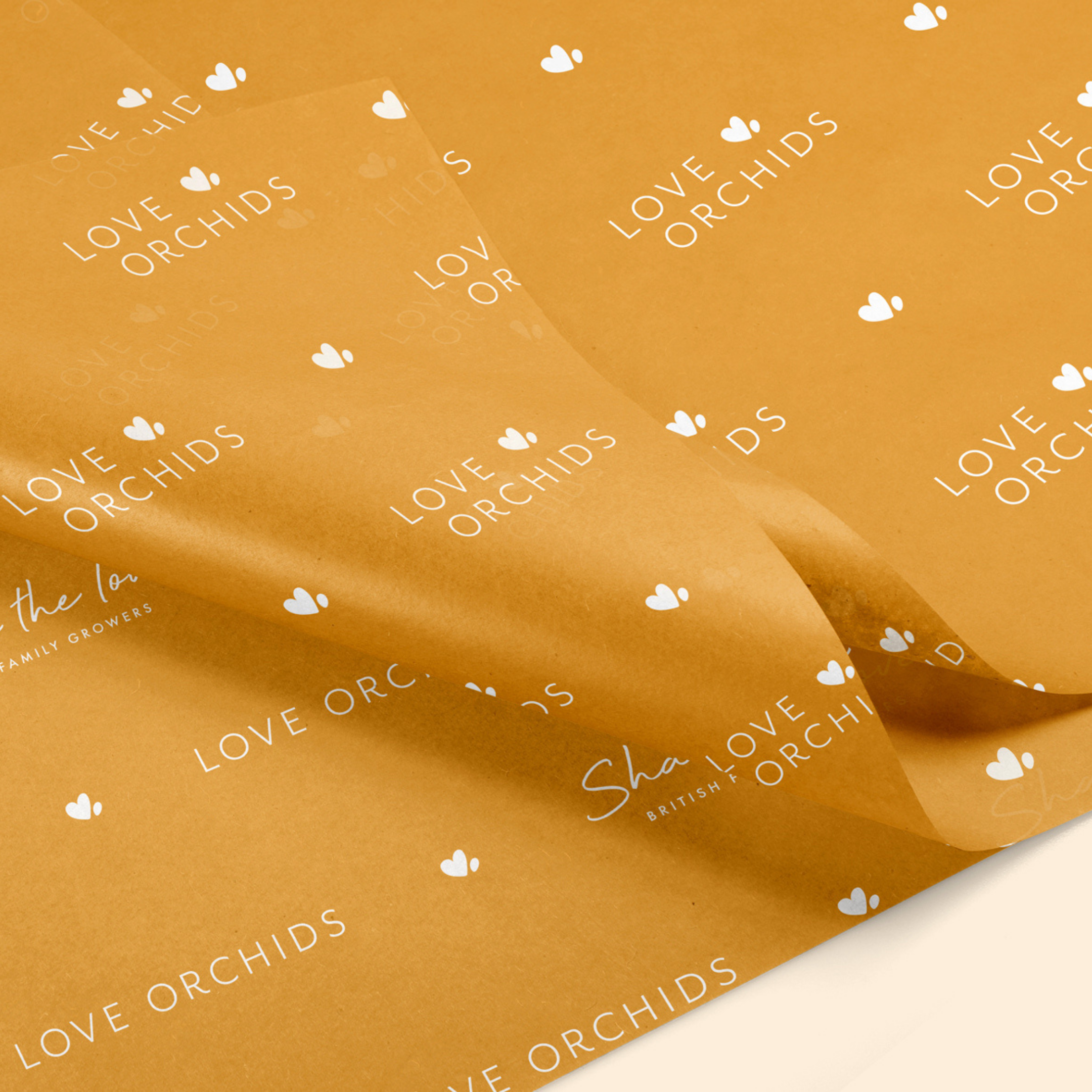 Close-up of orange-coloured tissue paper with white logos saying' LOVE ORCHIDS' with a small white heart.