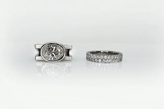 Transformation.  I was asked to reset an an oval diamond from a delicate classic setting into something a little more contemporary and in this case, dramatic.  We set the oval diamond east/west with parallel lines in platinum.  I actually think it su