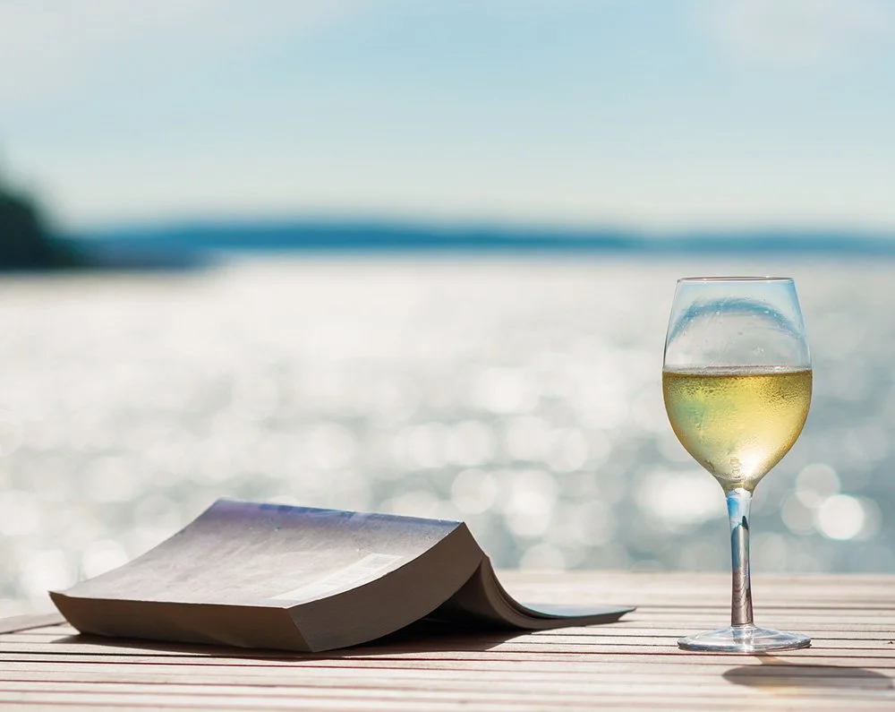 Drinking wine while reading at the beach
