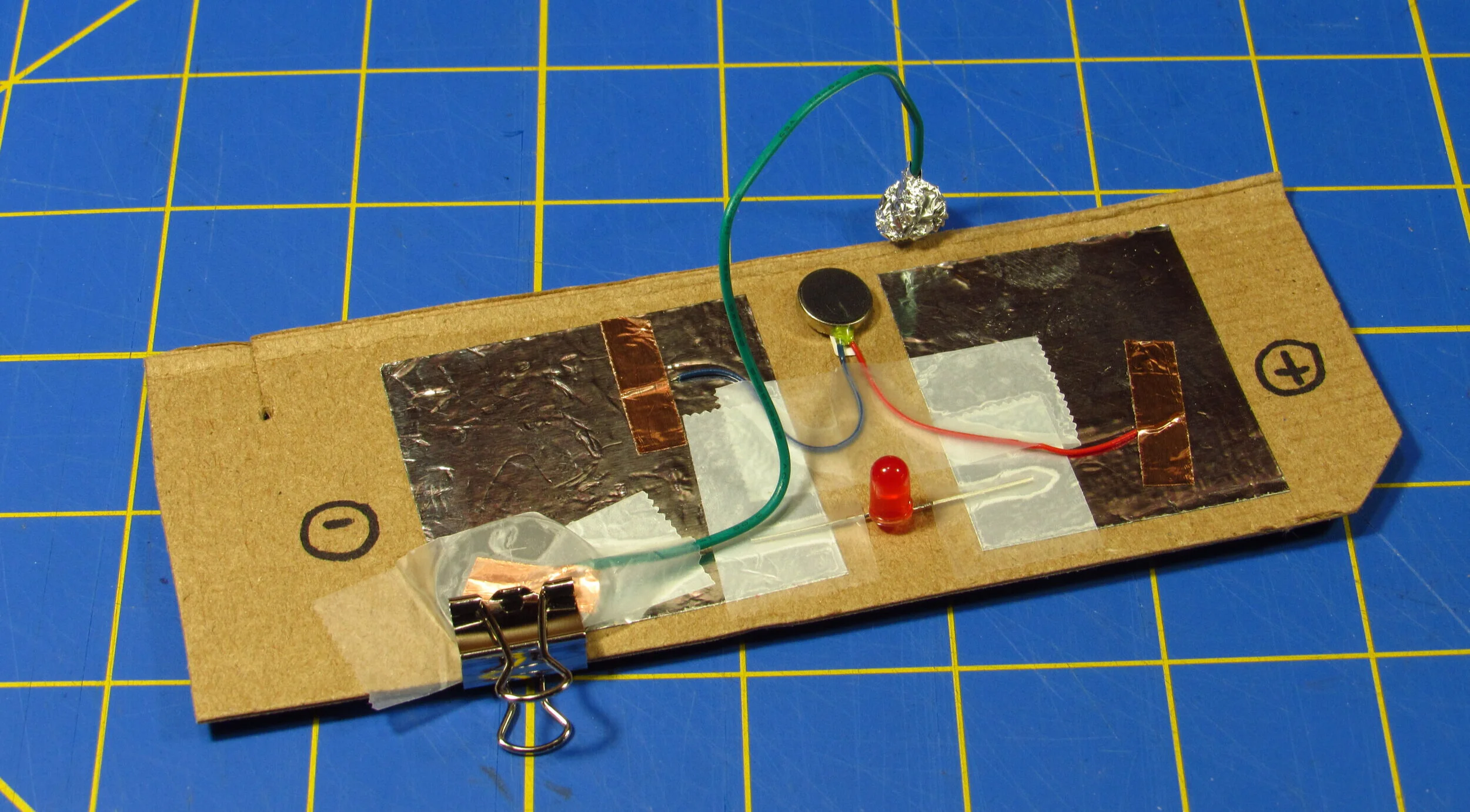Can you find the LED, the buzzer, the battery, and the wire that closes the circuit? (Click to enlarge the image.)