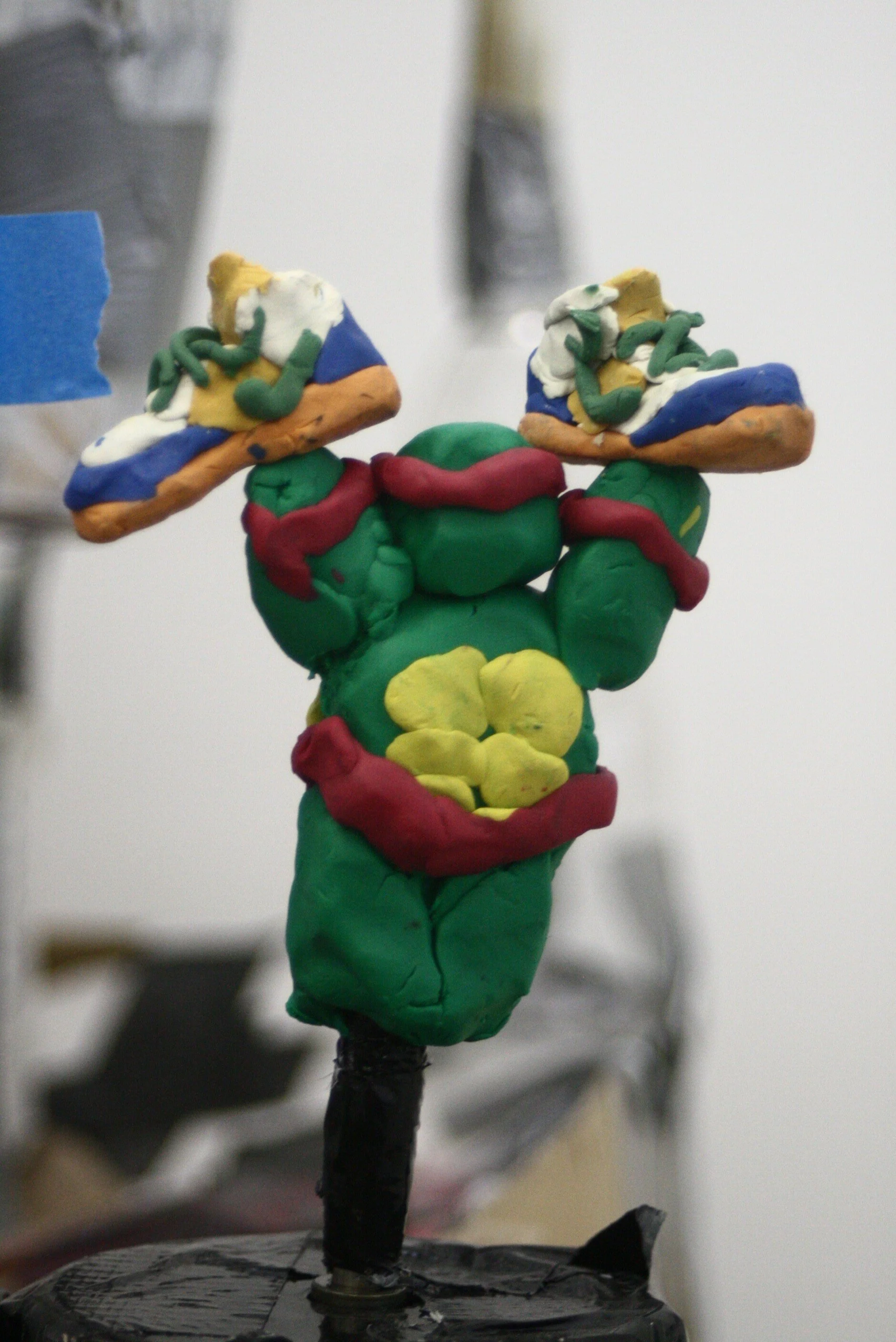 Raphael holding Nike shoes - 2009, installation detail; plastercine and mirror ball motor