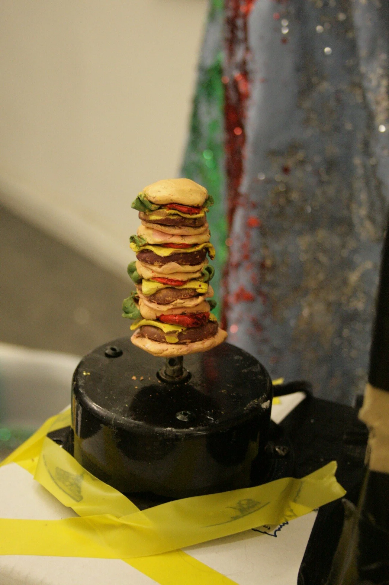 Ultimate burger - 2009, installation detail; painted clay figurine, mirror ball motor