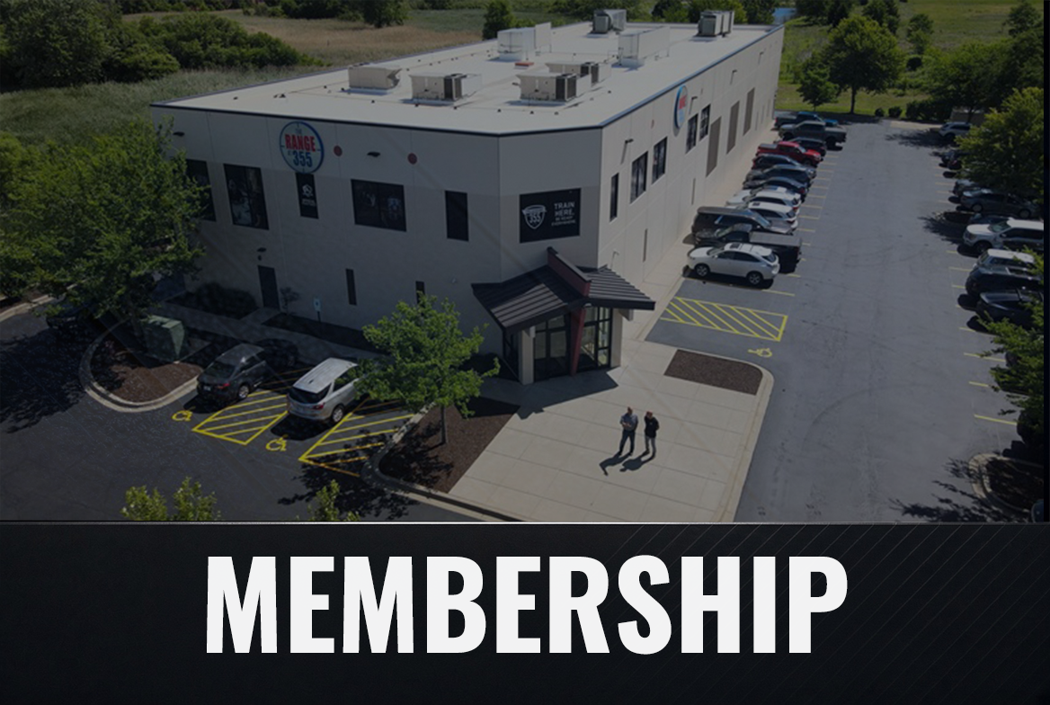 An aerial view of a modern building with parking lot, trees, and a few people walking outside. The building has signs indicating it is a sports or recreation facility, with the word 'MEMBERSHIP' at the bottom.