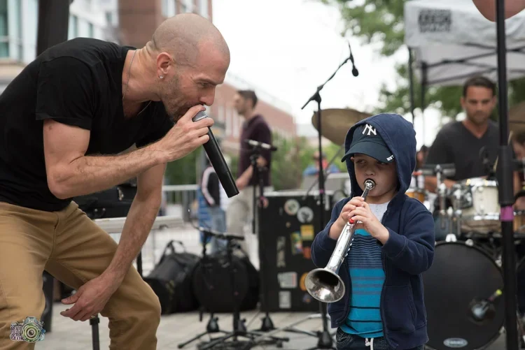 Performer from the Gun Poets, Dan, singing on stage