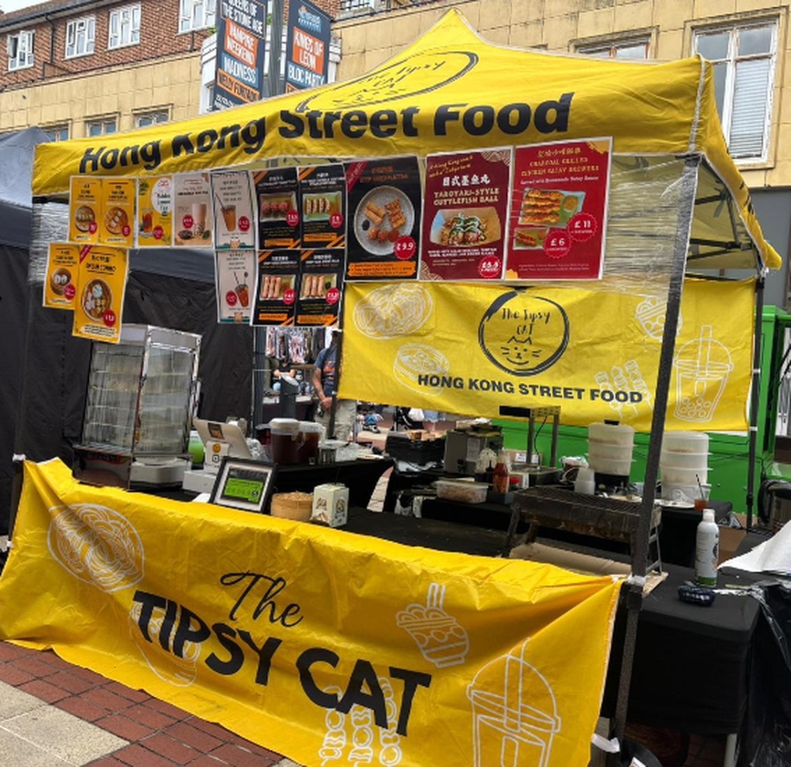 The Tipsy Cat stall - yellow gazebo and banners with the Tipsy Cat logo and menus