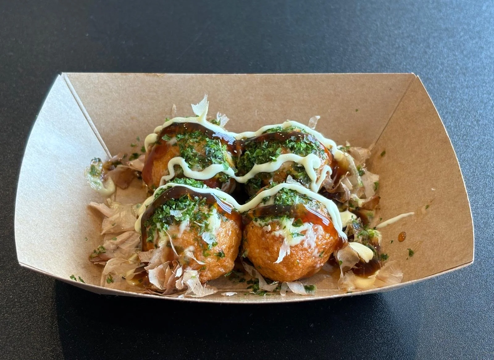 Takoyaki style cuttlefish balls in a cardboard carton