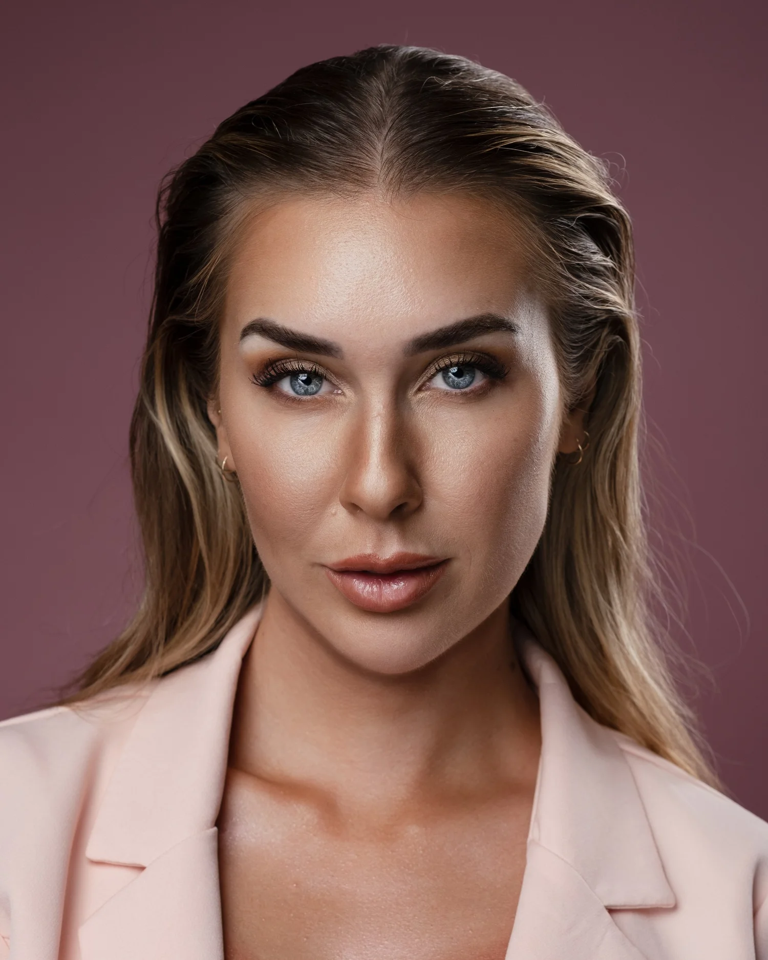 Editorial headshot of a woman in a pale pink blazer, Las Vegas studio