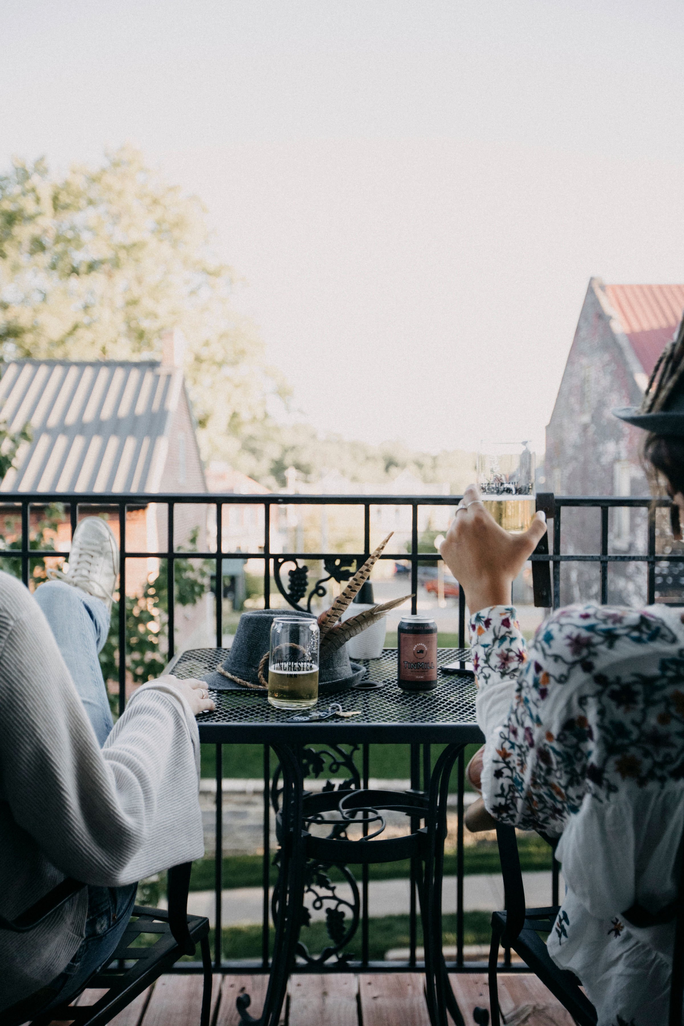 Two girls sitting on balcony, drinking beer