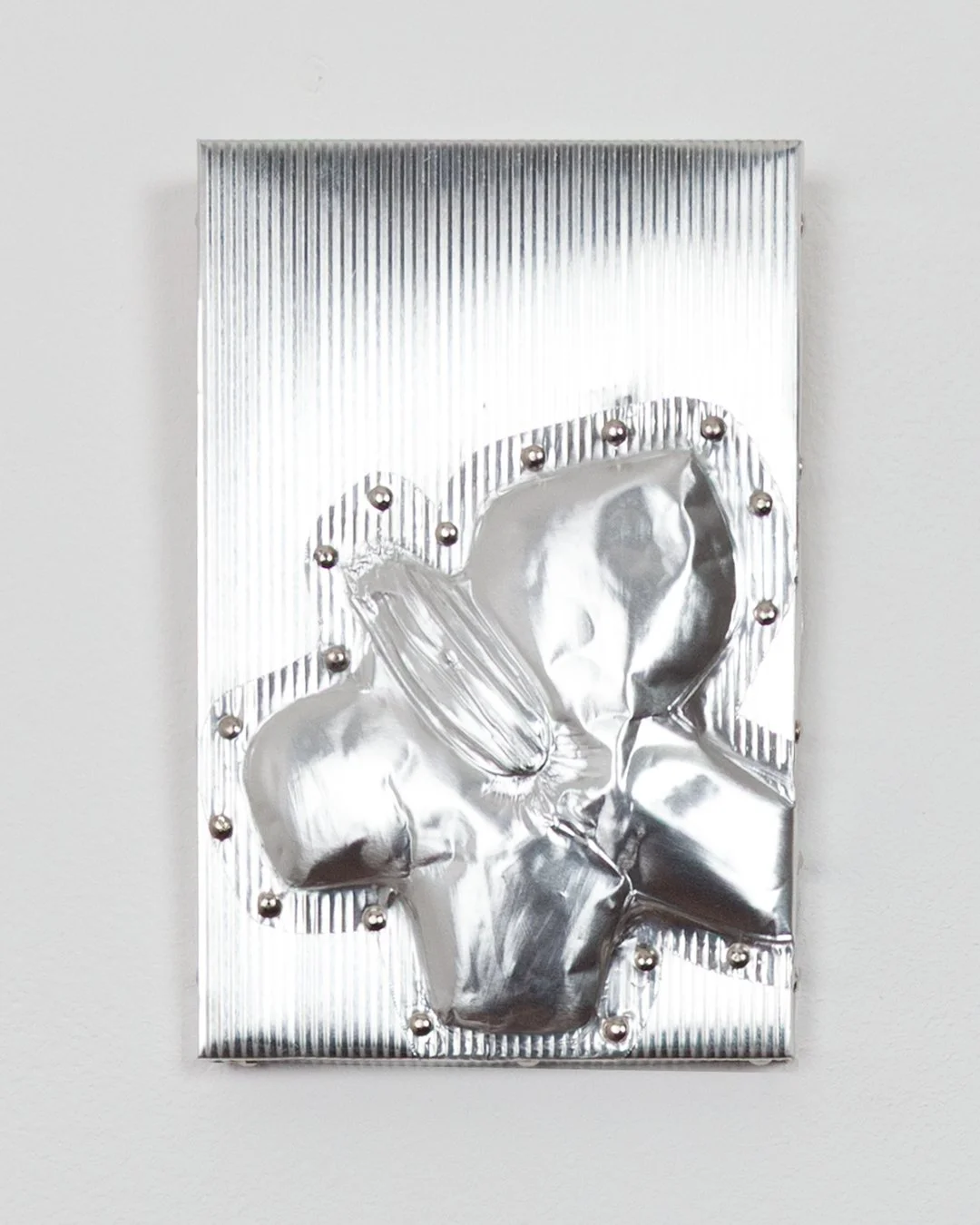 Rita Osipova, Held Absence , corrugated metal, plywood, nails, 15cm x 10cm x 1.2cm, 2025