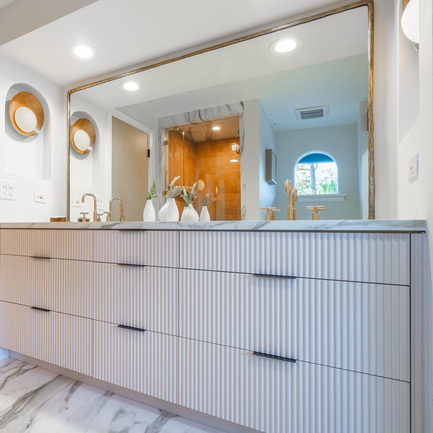 REED ALL ABOUT IT - Texture created with fluted cabinetry combined with pattern from marble elevates a space with refined elegance.

📸 @wearetwocreative 

#doneraildesign #decor #designelements #bathroom #bathroomdesign #masterbathroom #bathroomreno