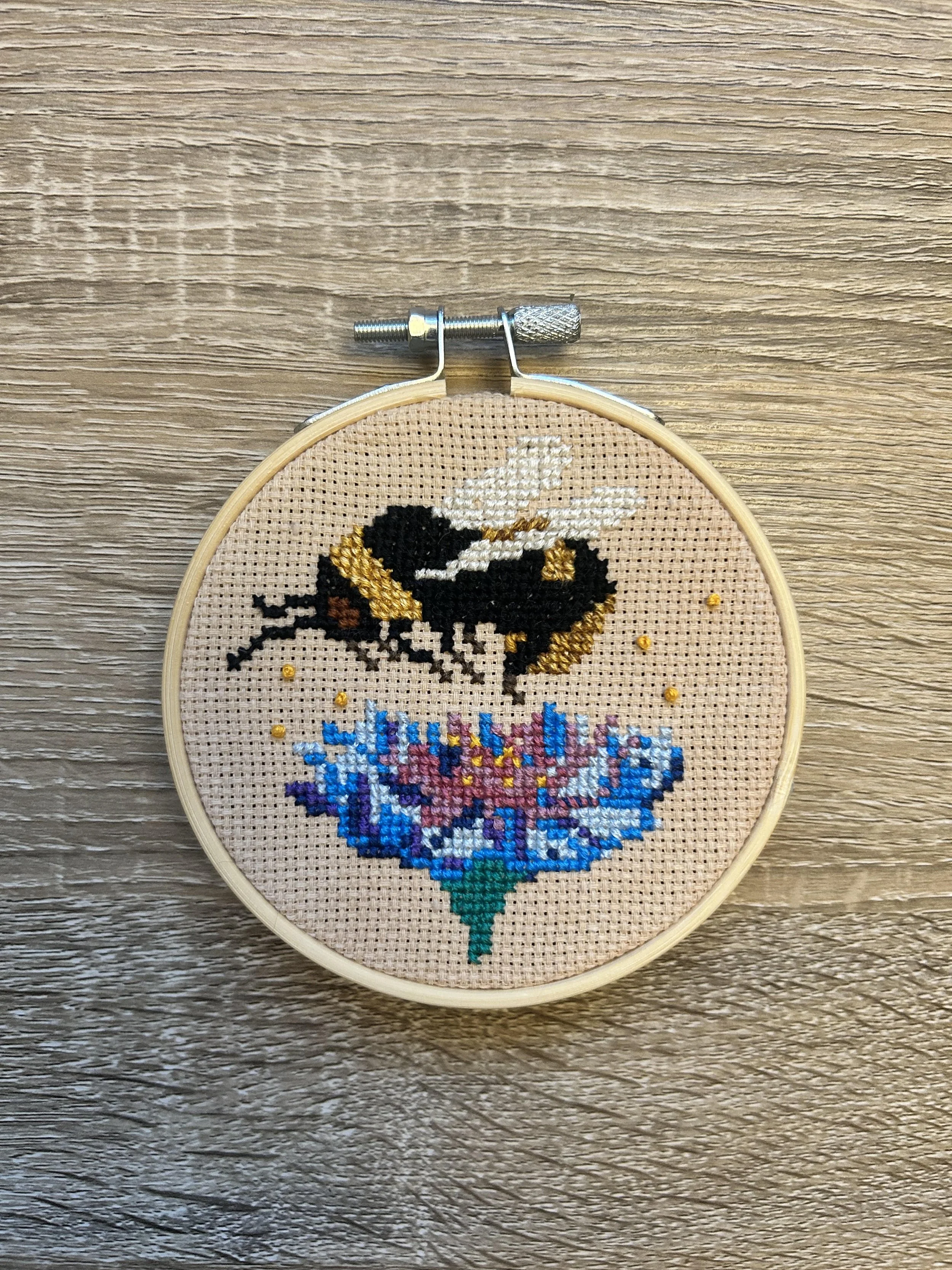 A cross-stitch bee and flower design