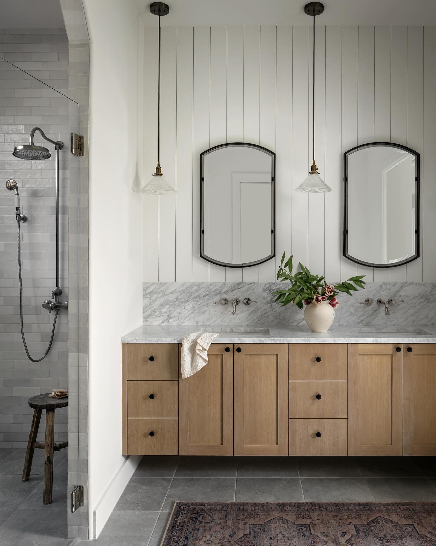 The first-floor primary suite acts as a private escape for the homeowner. Lauren chose to create visual interest through various forms of texture. The primary bedroom boasts a tall vaulted ceiling, uniquely detailed with tongue-and-groove and beams. 