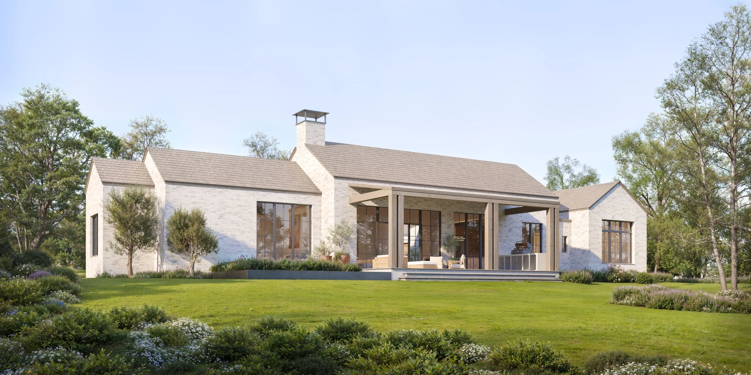 Modern house with large windows, sitting on a green lawn surrounded by trees and shrubbery, with a covered patio area.