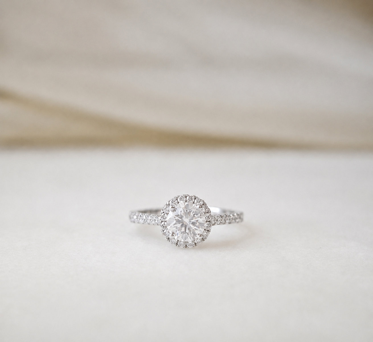 GIA-certified 0.80ct haloire engagement ring with a diamond band in 18K white gold by Lovélle Jewellery