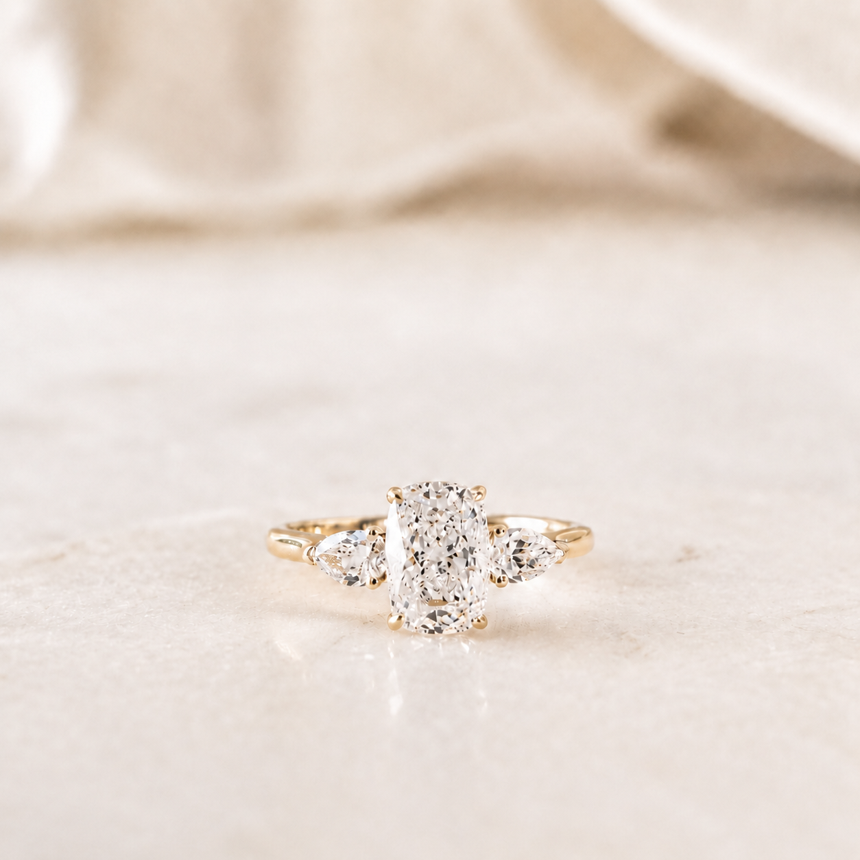 The Victorian Floating Ring featuring a 2.00ct cushion lab-grown diamond with two pear-cut side diamonds in 14K yellow gold by Lovélle Jewellery