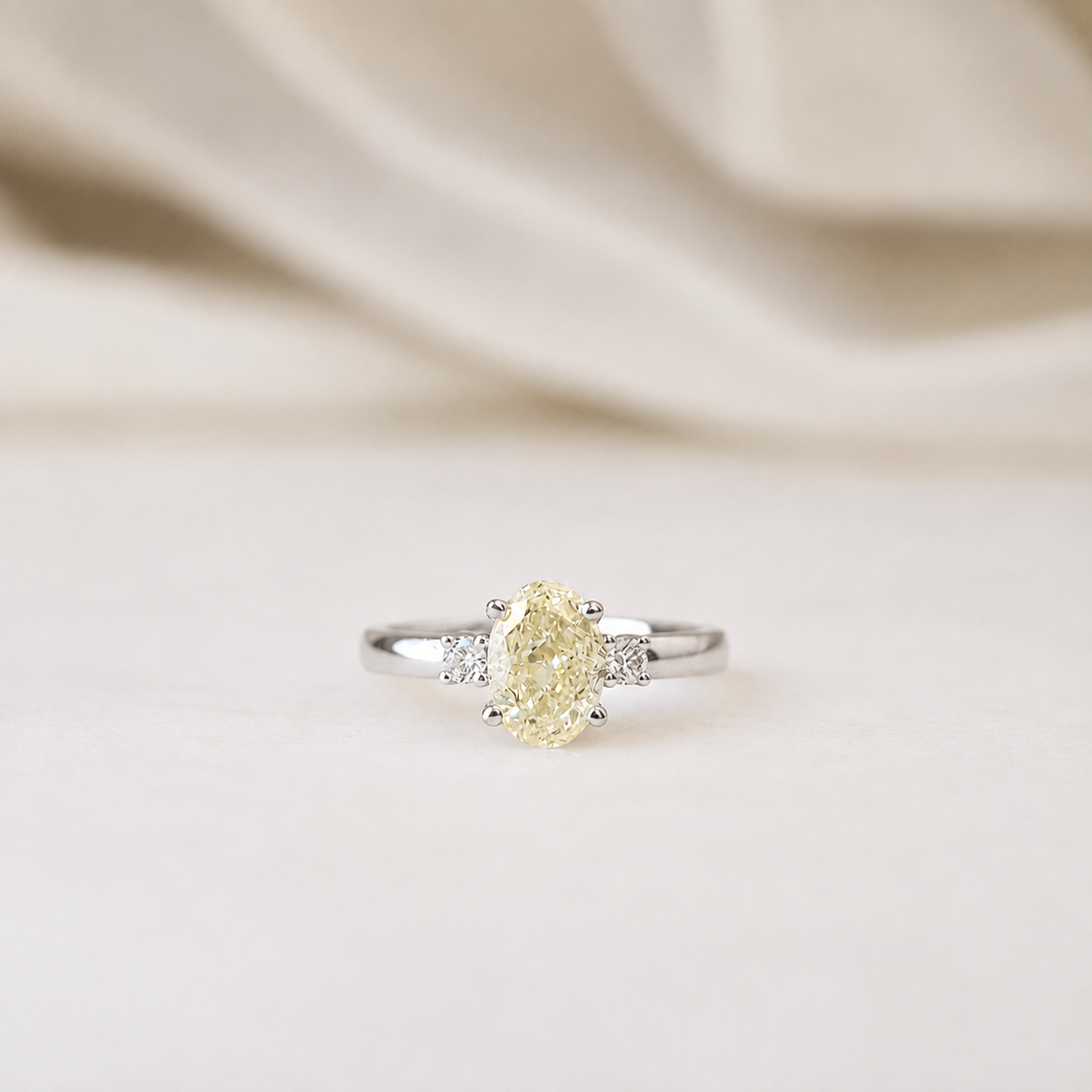 The Cosmic Ring featuring a 1.07ct fancy yellow oval lab-grown diamond with two accent diamonds in 18K white gold by Lovélle Jewellery