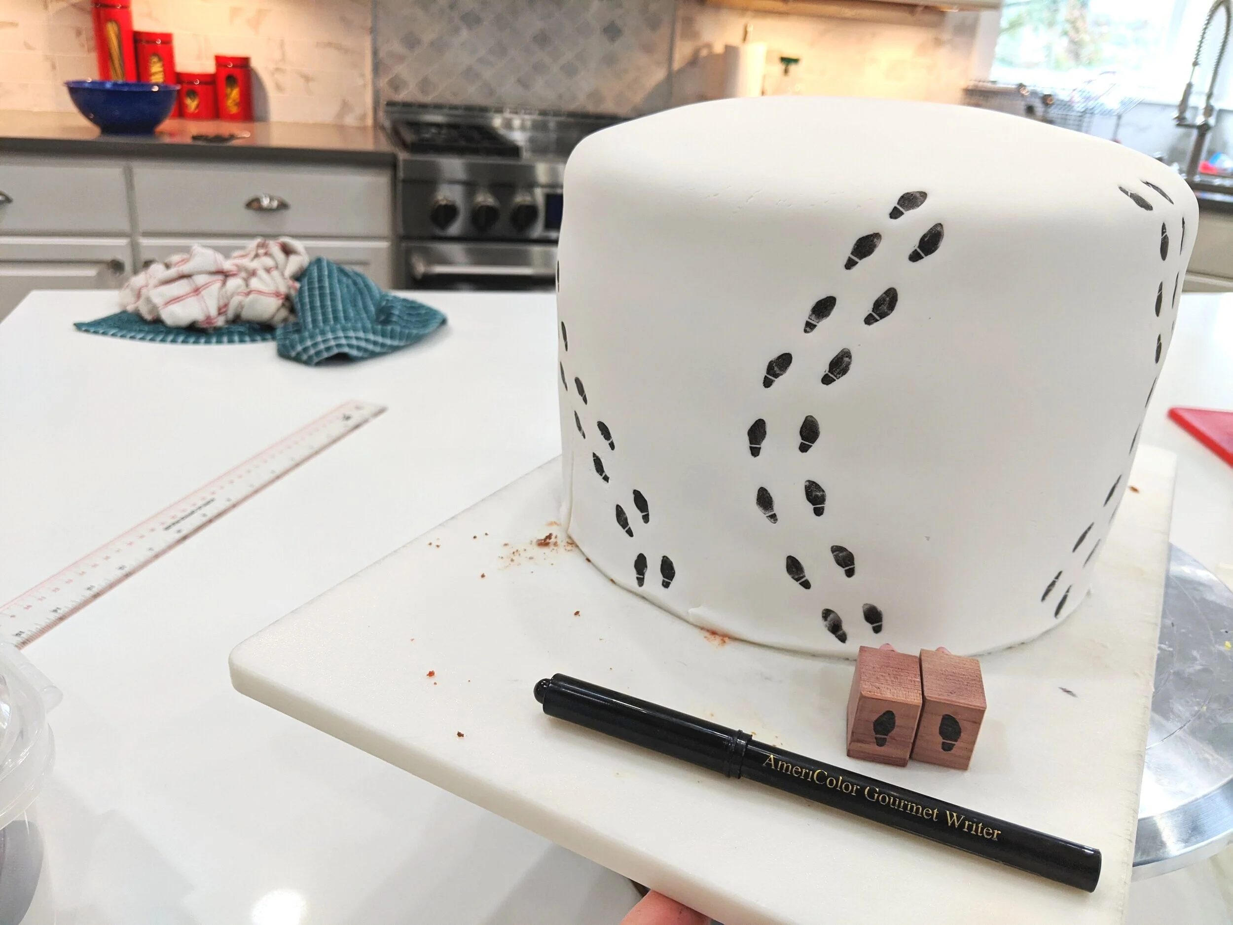 I purchased little shoe print rubber stamps from Etsy and used a food marker to add Marauder’s Map footprints all around the bottom tier.