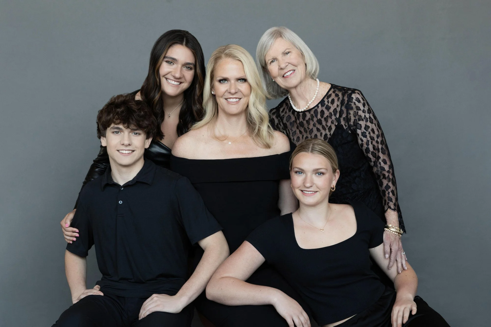  Multi generation family portrait with grandmother, mother, and children dressed in black, showcasing connection and legacy through family photography. 