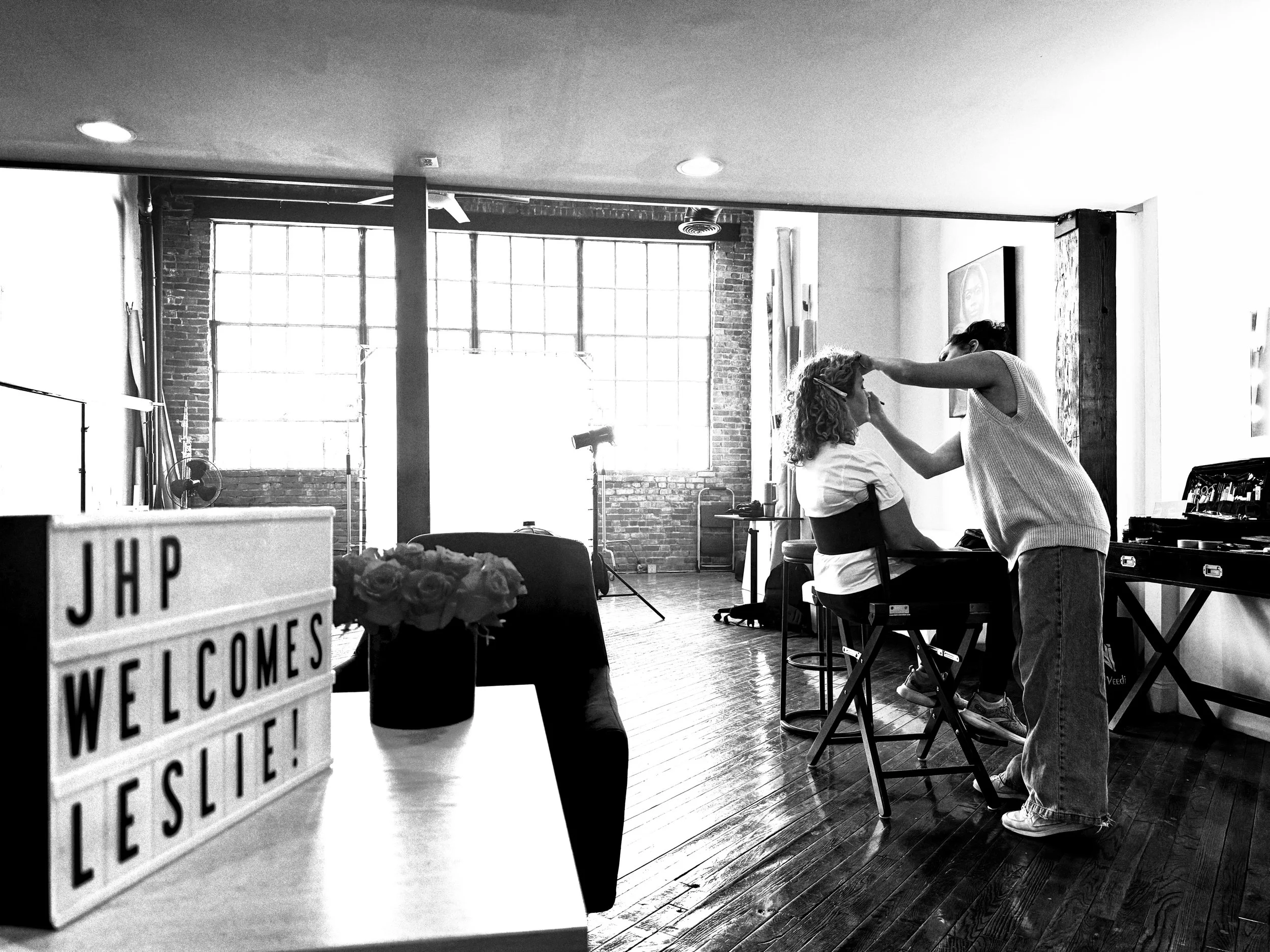  Black and white BTS shot of a client getting hair and makeup in Judith’s Nashville Portrait Studio. 