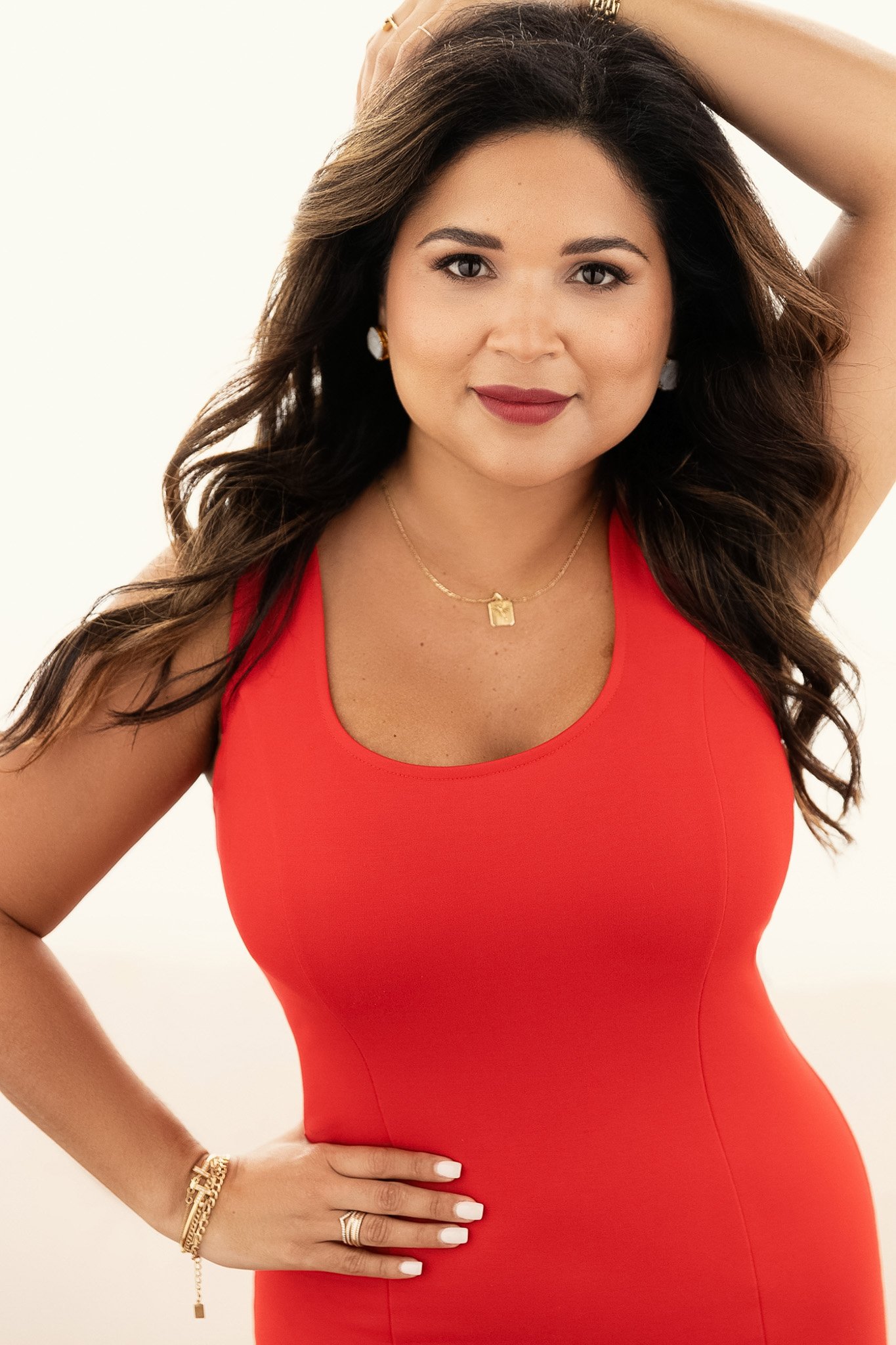 Woman in a red dress with her hand in her hair, Nashville beauty portrait by Judith Hill