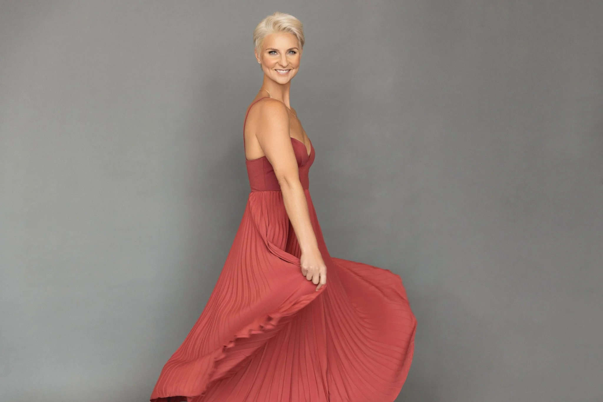 Woman twirling in a flowing coral gown, Nashville movement portrait by Judith Hill