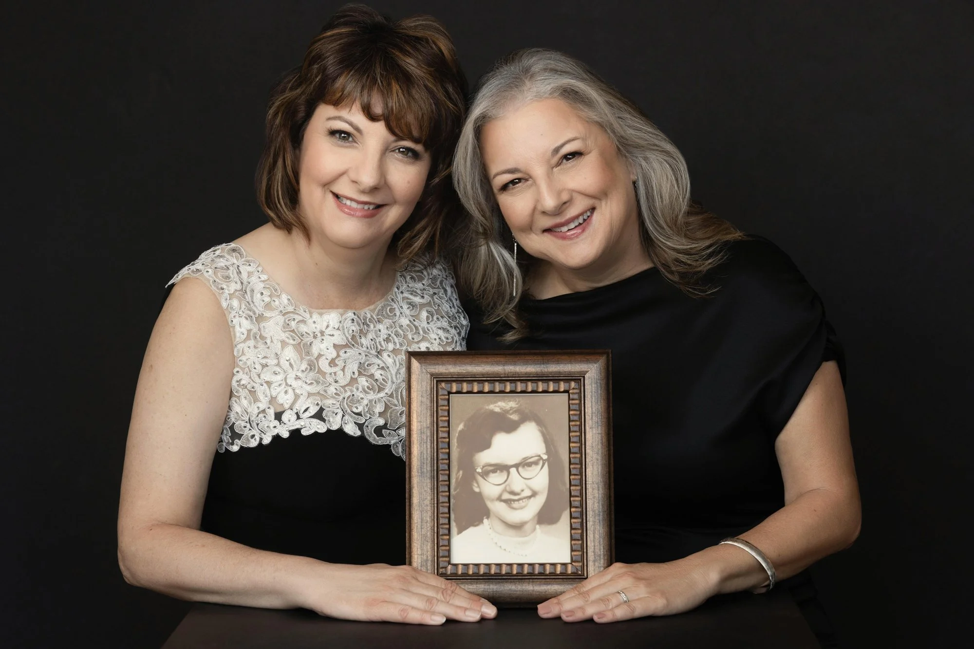 Two sisters holding a framed vintage family photograph, Nashville legacy portrait by Judith Hill