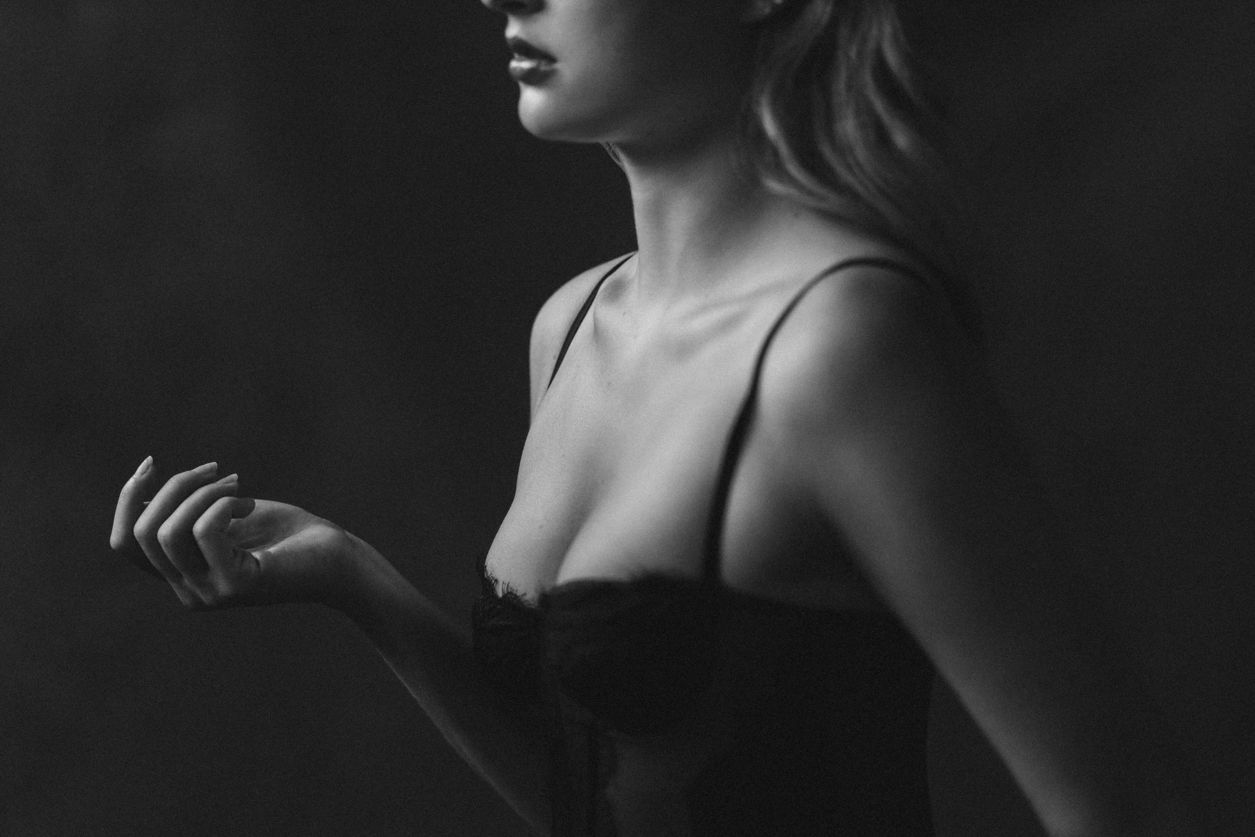 Moody black and white detail of a woman's collarbone and hand in a black camisole — intimate Nashville boudoir portrait