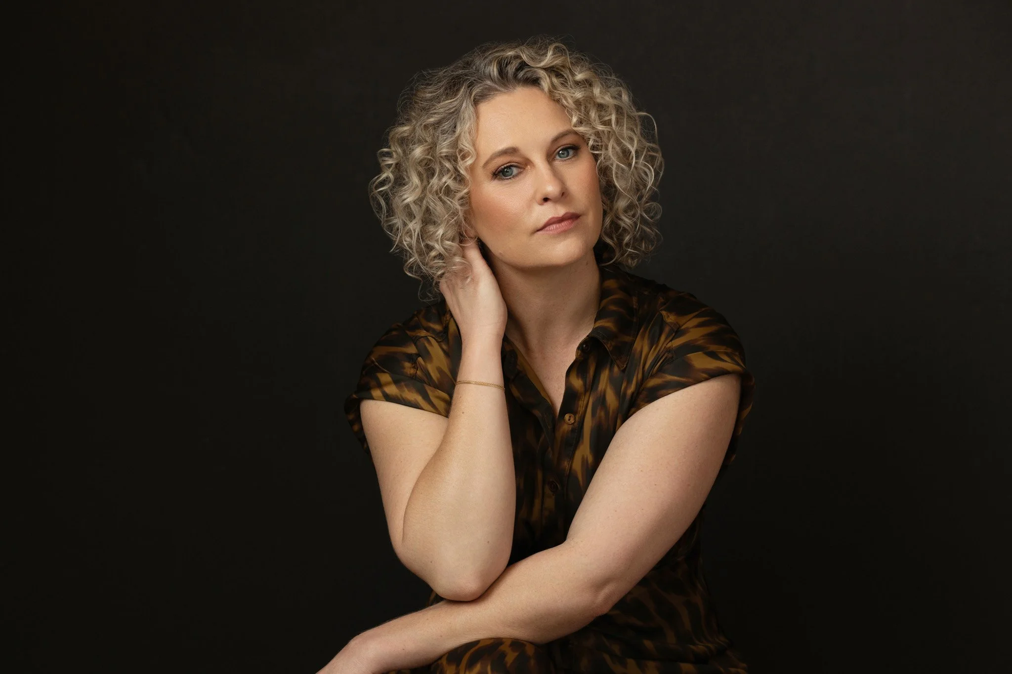 Woman with curly blonde hair in an animal-print blouse, Nashville studio portrait by Judith Hill