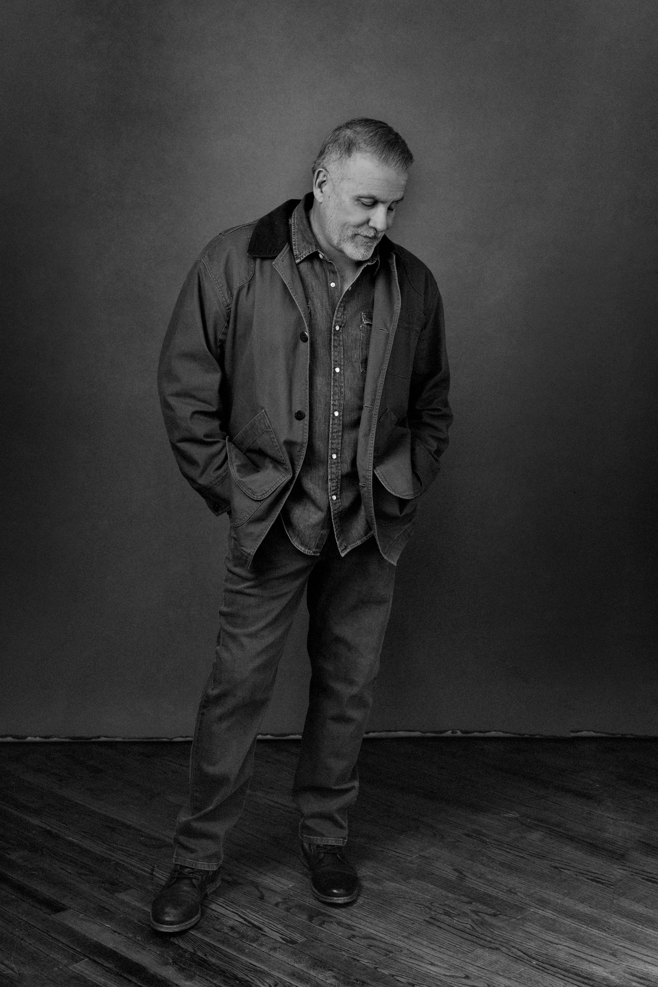 Black-and-white portrait of a man in a denim jacket looking down, Nashville men's portrait by Judith Hill