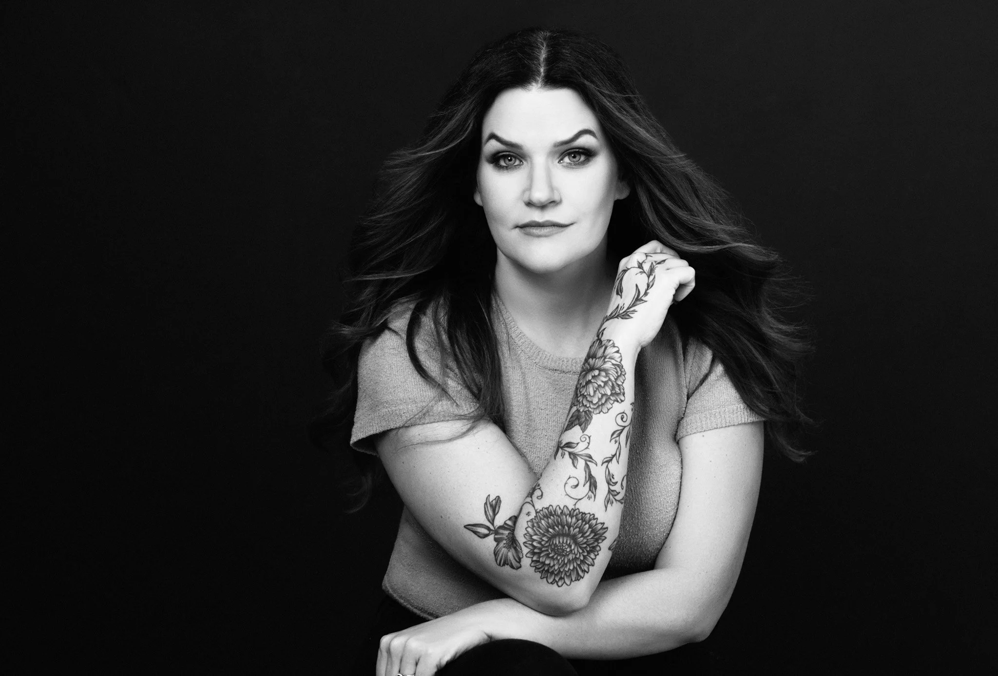 Black-and-white portrait of a woman with a floral arm tattoo, Nashville studio portrait by Judith Hill