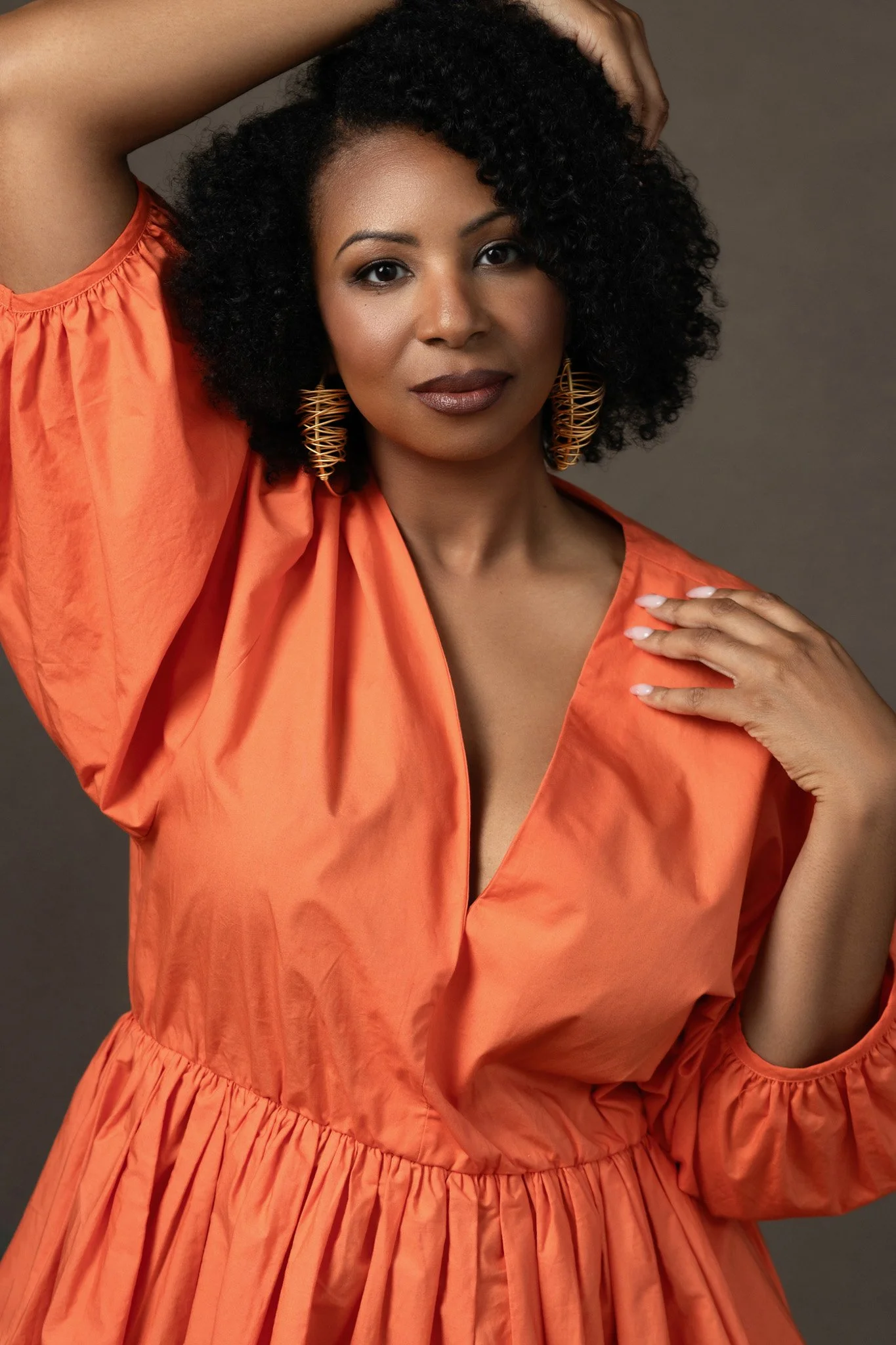 Black woman with natural curls in an orange dress, Nashville beauty portrait by Judith Hill