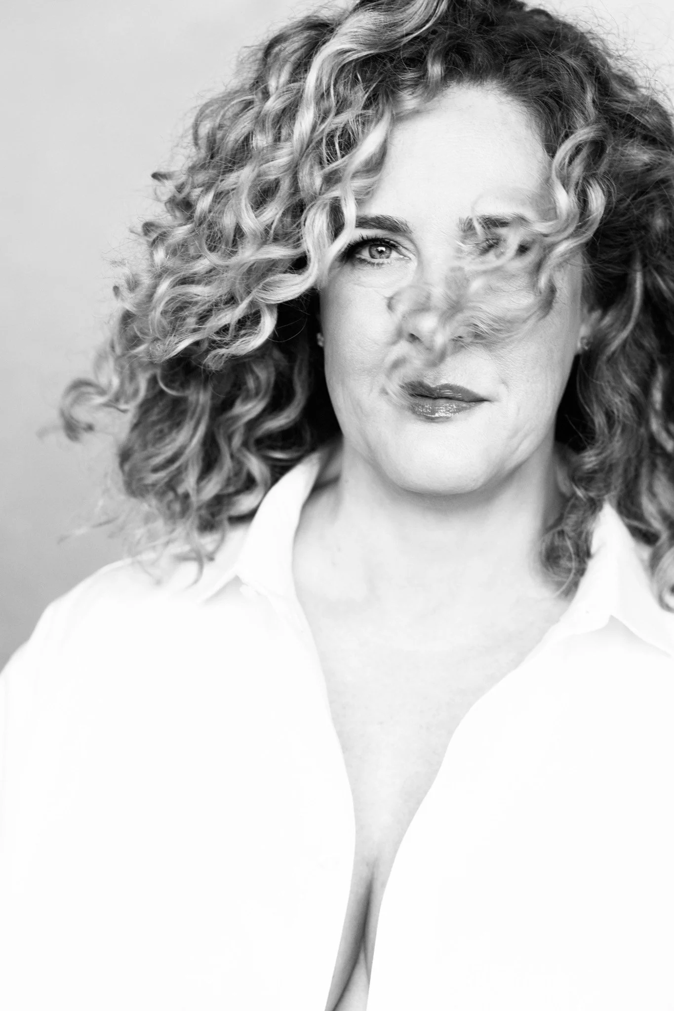 Black and white Nashville studio portrait with hair swept across the face by Judith Hill Photography