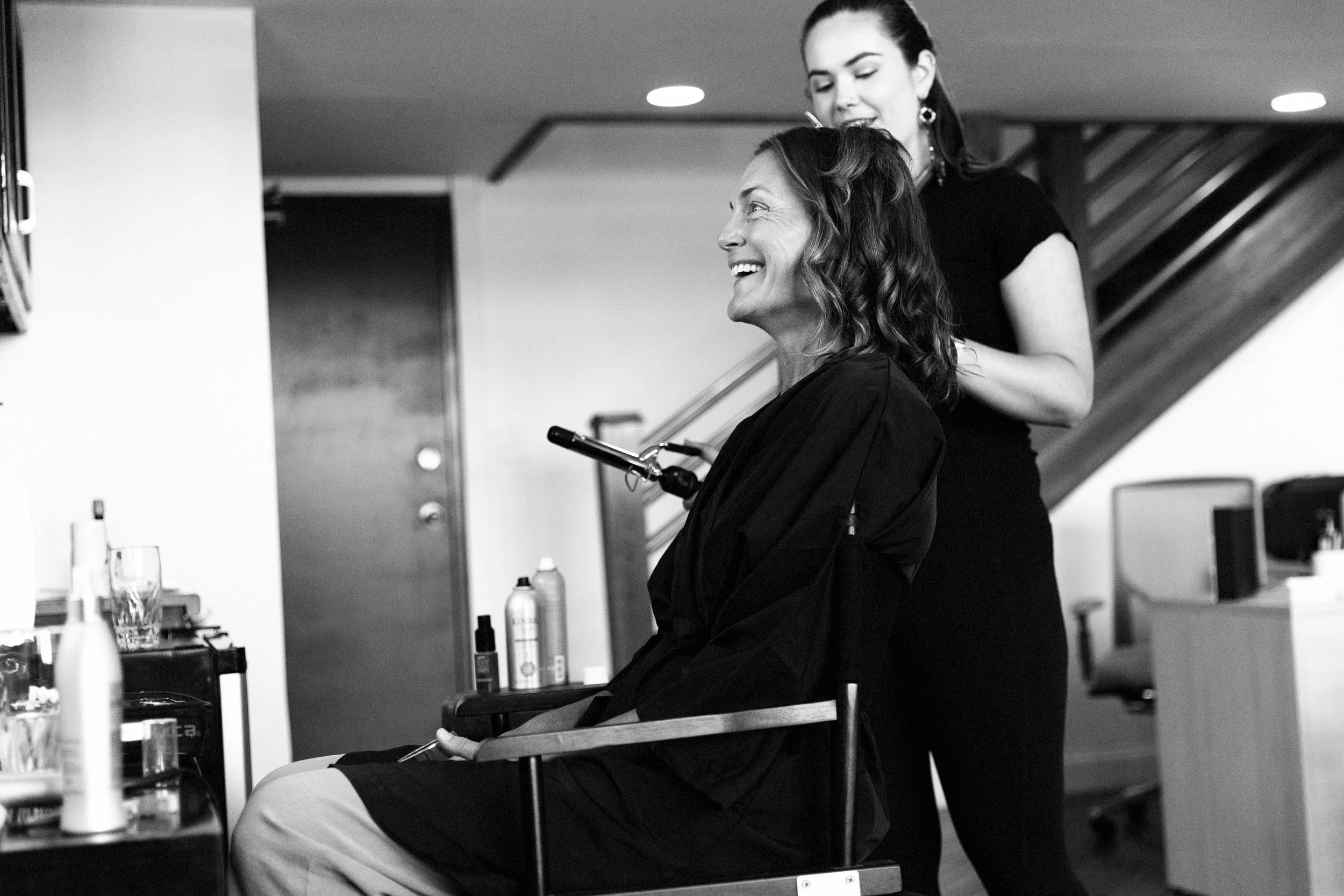 Woman over 40 laughing during hair and makeup before her photoshoot in Judith Hill's Nashville Portrait Studio.