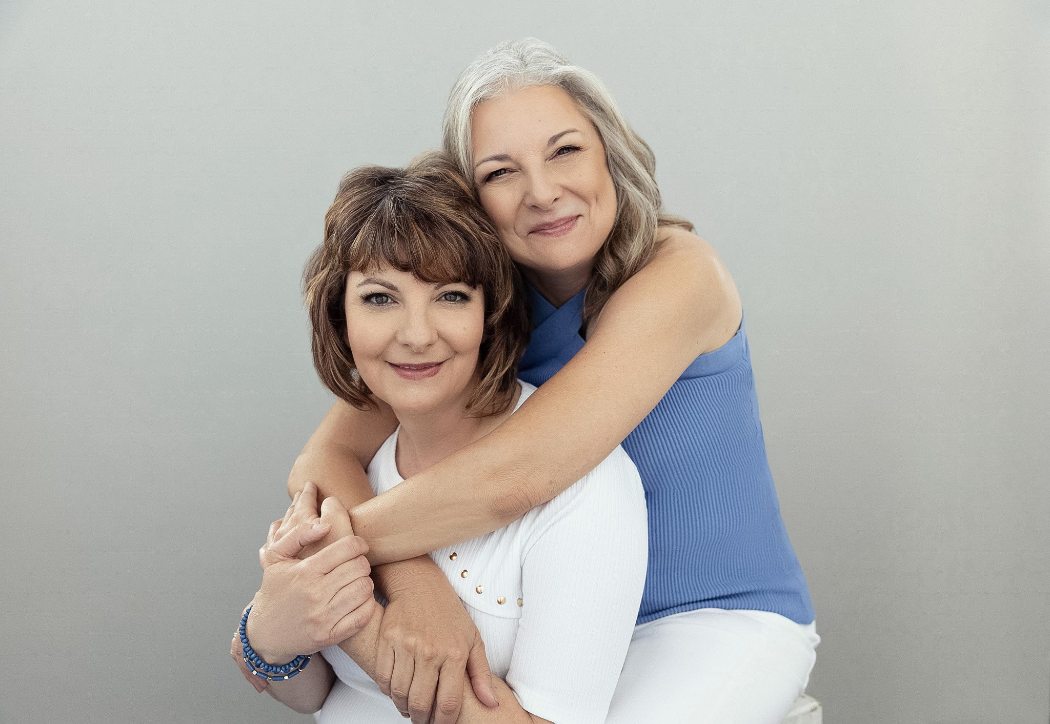 Two women embracing in blue and white, Nashville friendship portrait by Judith Hill
