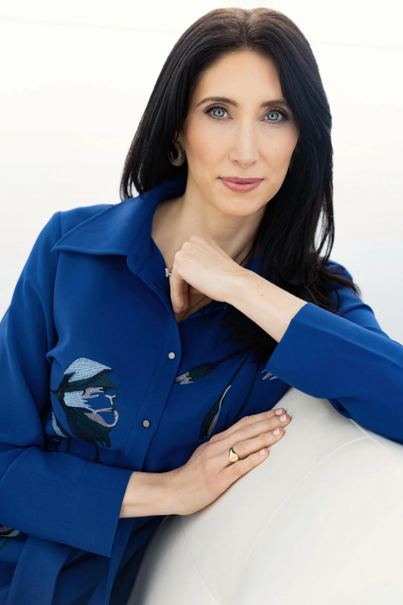 Woman in a blue blouse seated on a white sofa, Nashville natural-light portrait by Judith Hill