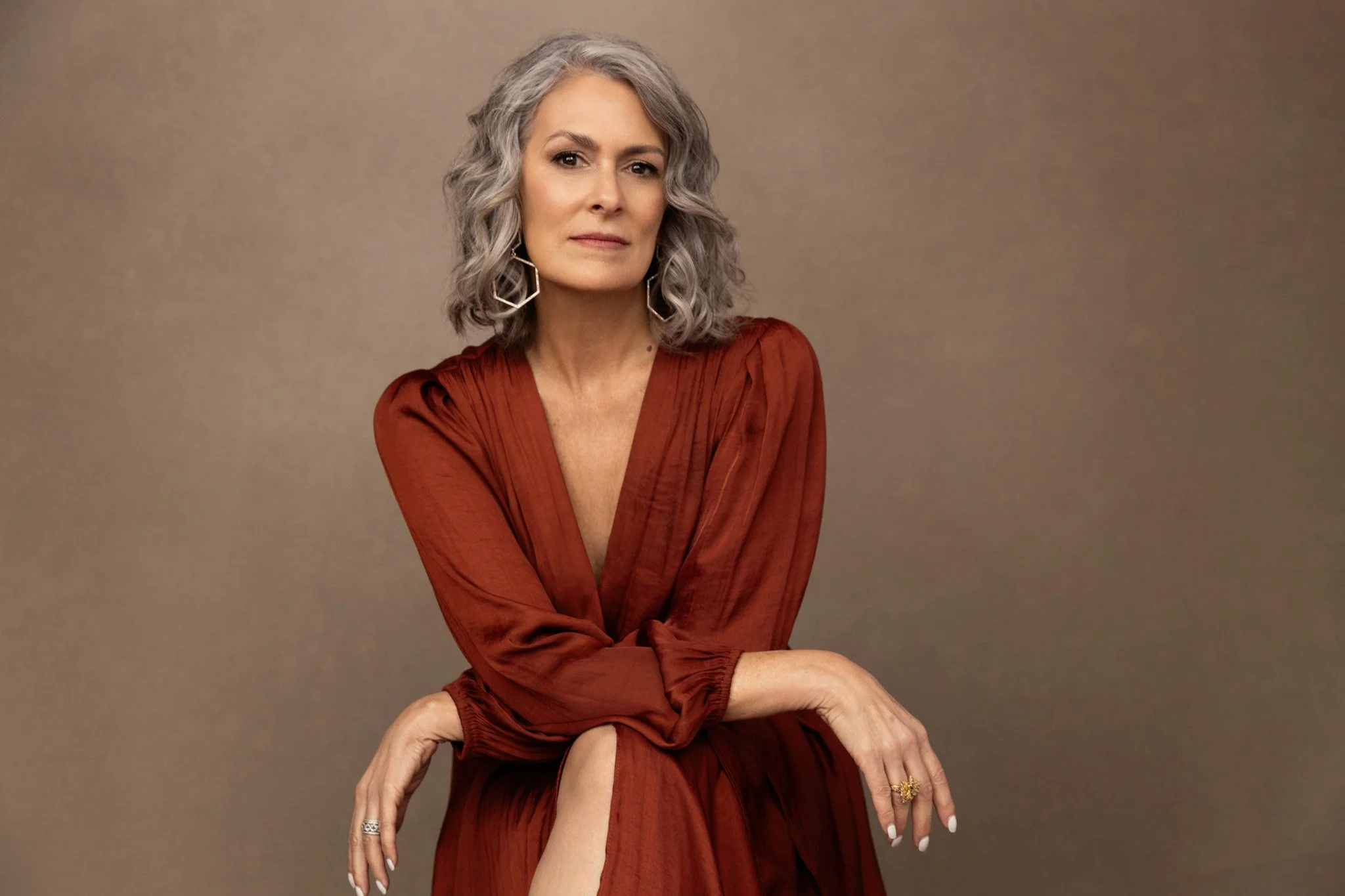 Silver-haired woman in a rust wrap dress, Nashville studio portrait by Judith Hill