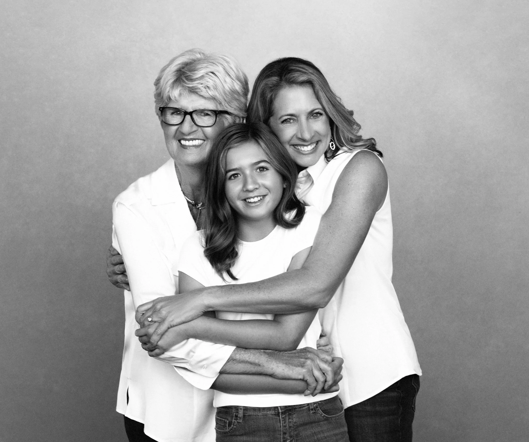 Three generations of women embracing in white, black-and-white Nashville generations portrait by Judith Hill