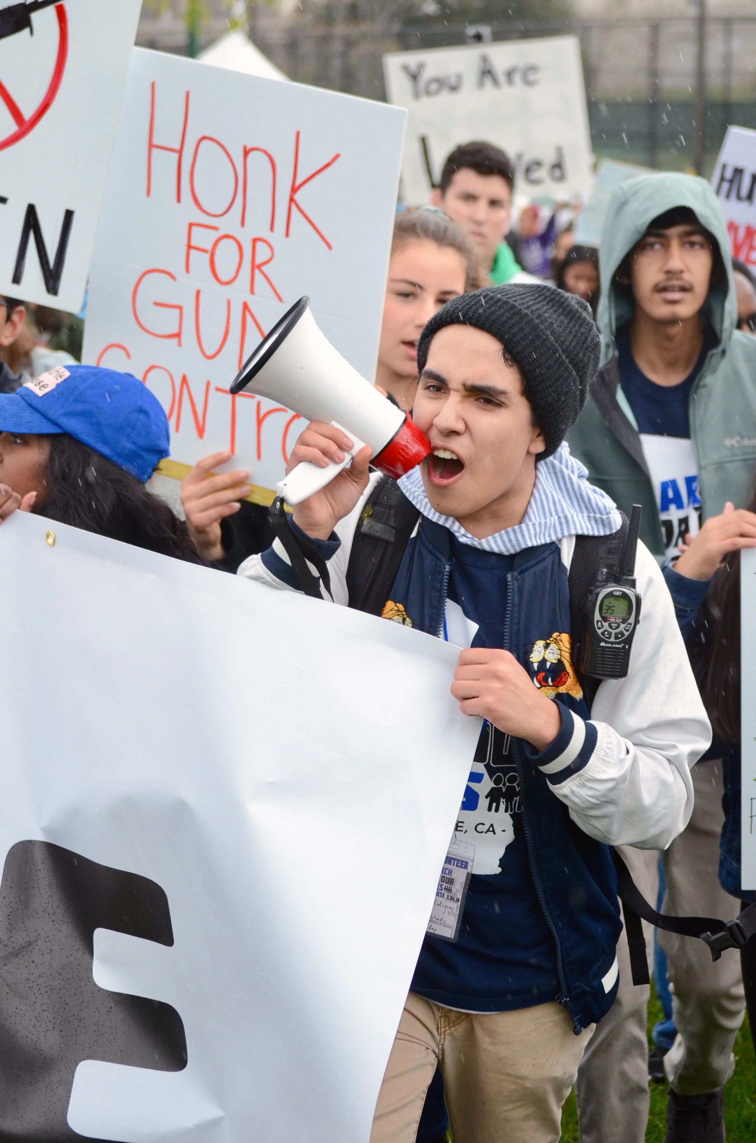 A high schooler from Prospect High School helps to hold a banner and lead chants at the front of the march. The March for Our Lives protest in San Jose was organized by Bay Area students. Photo by Eric Fang
