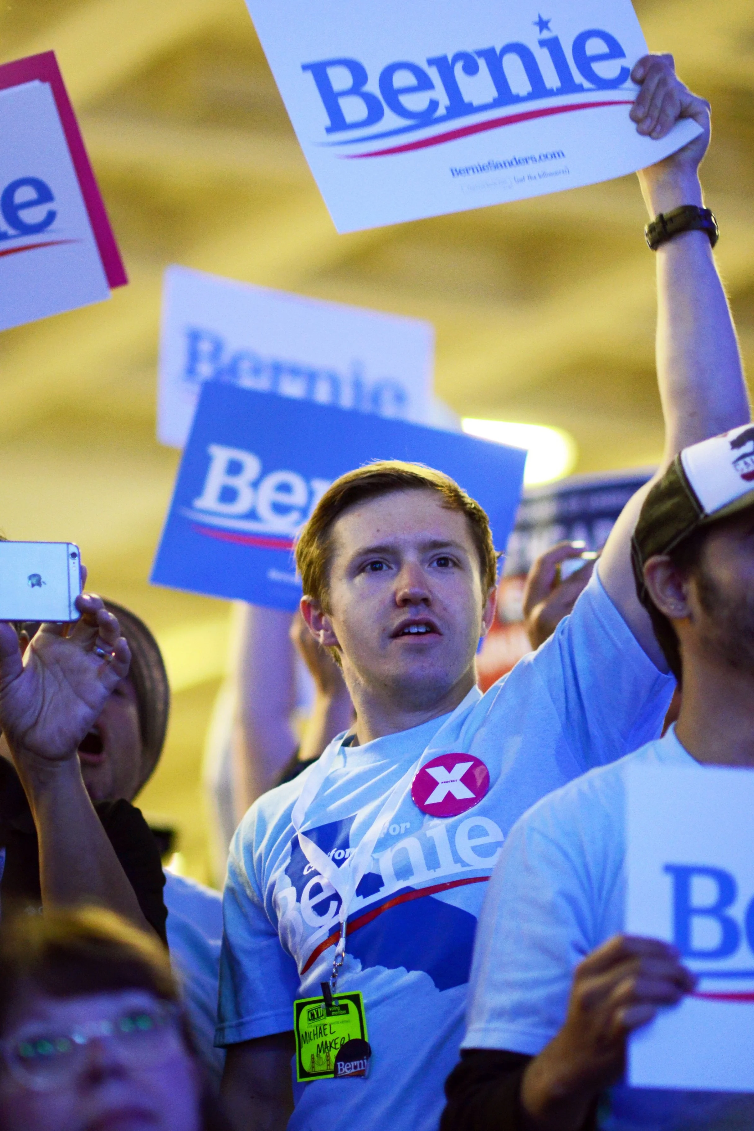 An audience member at the California Democratic State Convention rises in support of Sen. Bernie Sanders at the beginning of his speech. Sanders spoke in support of universal healthcare. Photo by Eric Fang